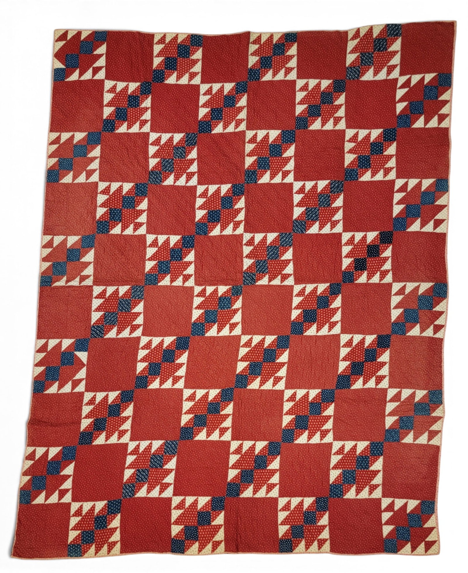 RED AND BLUE PIECED QUILT: American, late 19th century. Printed red, blue, and cream fabrics, pieced in a grid pattern, and with a printed back. 84.5" by 64". Provenance: an Ohio collection. NOTE: We are happy to answer