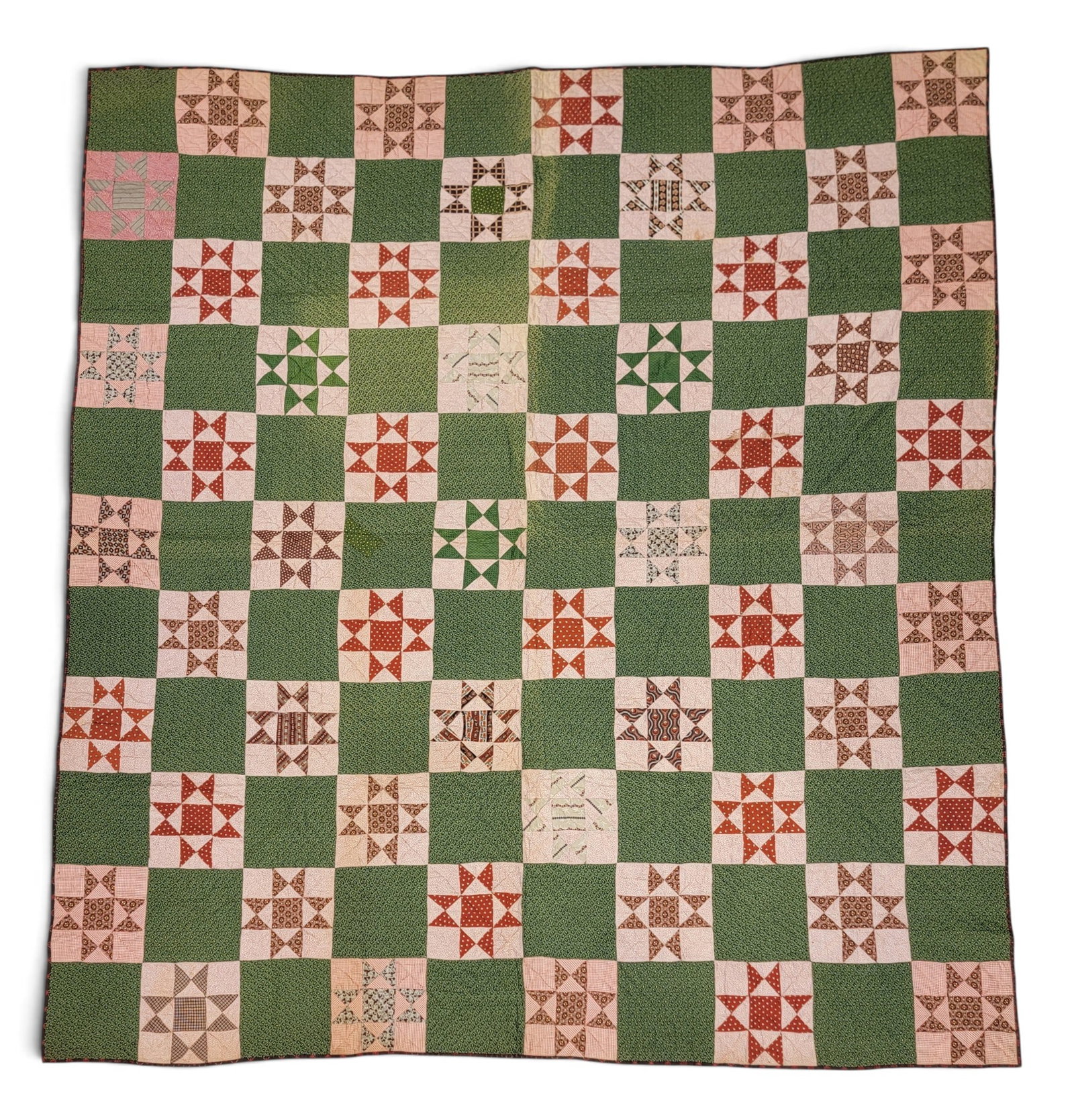 OHIO STAR QUILT: Attributed to New York State, 3rd quarter-19th century. All printed fabrics, with 55 Ohio stars in a grid against a green ground, and with a checked back. 88" by 79". Provenance: an Ohio collection.