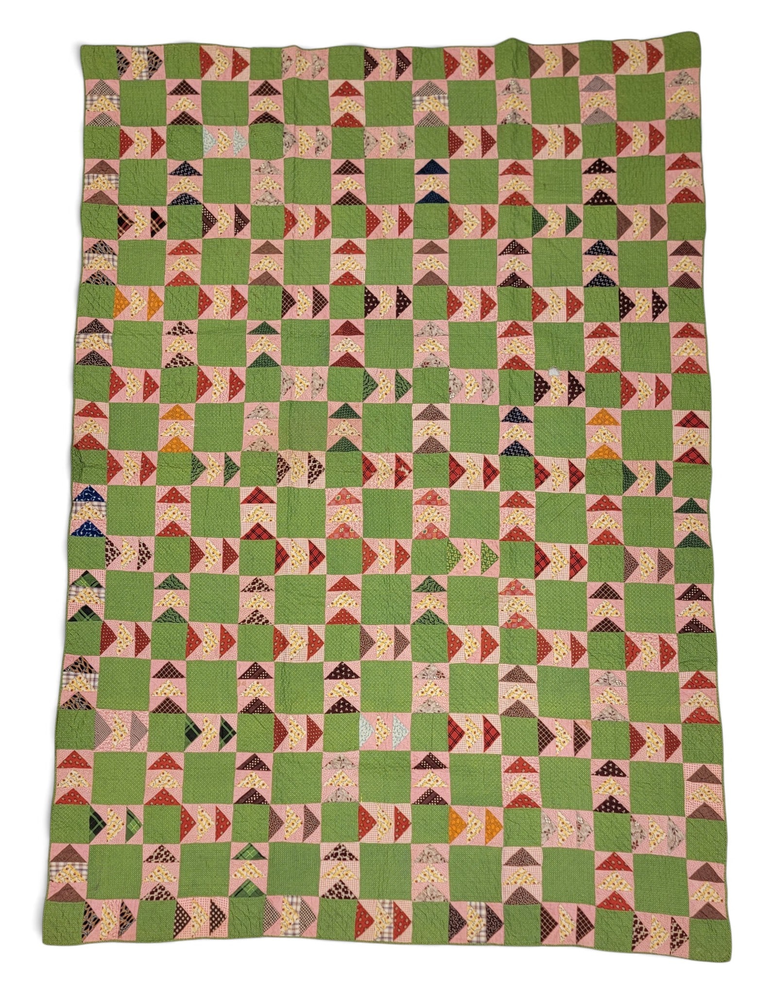 FLYING GEESE VARIANT QUILT: Attributed to New York State, 3rd quarter-19th century. All printed fabrics, with criss-crossing triangles against a vibrant printed green ground, the back with brown print. 96" by 66". Provenance: