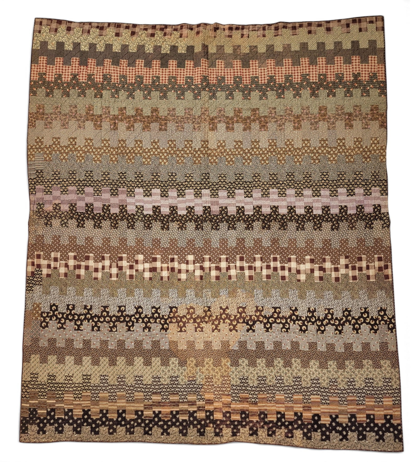 FANCY PIECED QUILT: American, 2nd half-19th century. In a zipper-like pattern, with each row a different fancy printed fabric in shades of brown, the back with printed brown fabric. Provenance: an Ohio collection. NOTE: