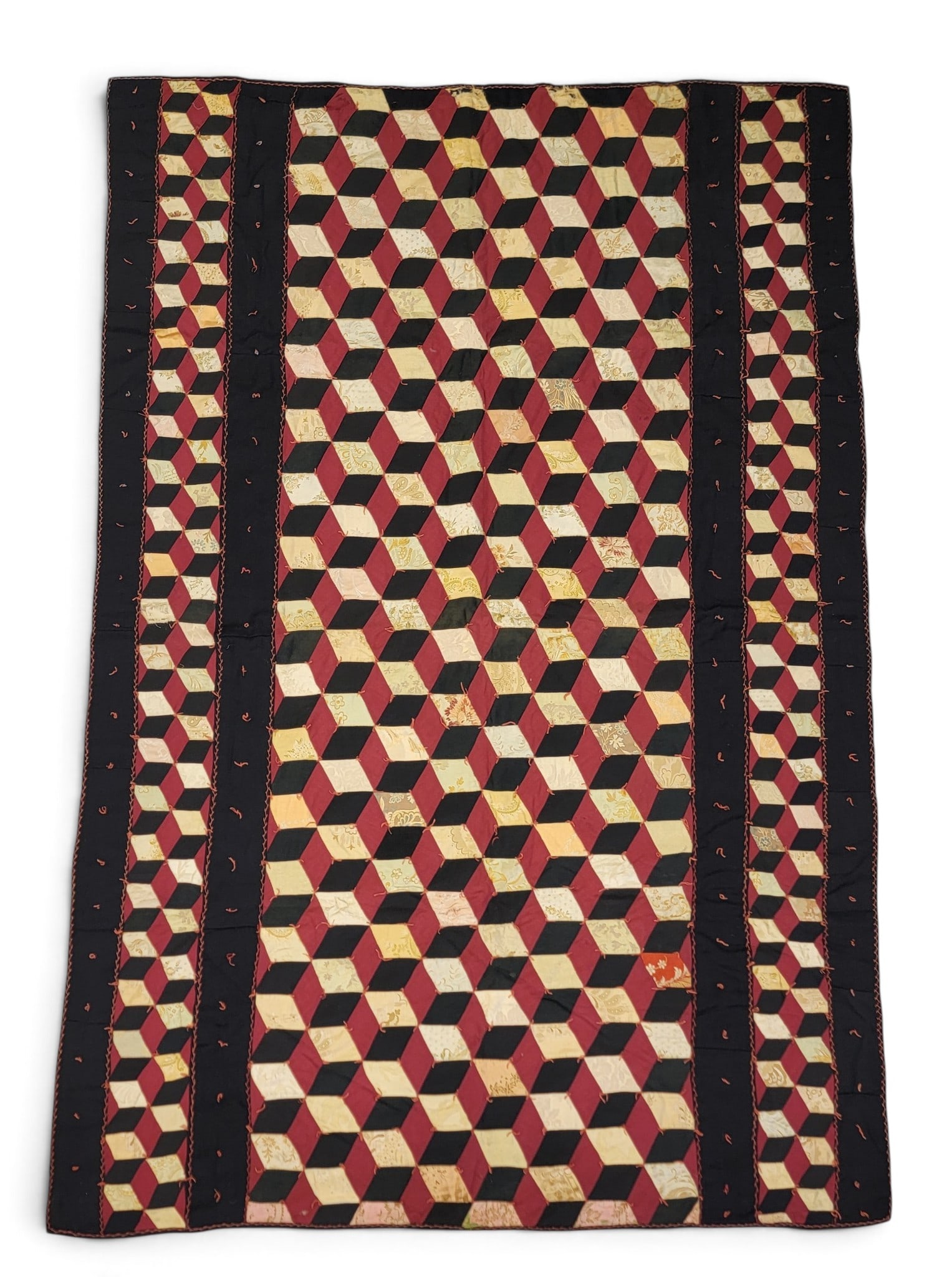 TIED TUMBLING BLOCKS QUILT: American, early 20th century. Tumbling blocks of red, black, and printed yellow fabrics, and with a red and black back. 80" by 54". Provenance: an Ohio collection. NOTE: We are happy to answer