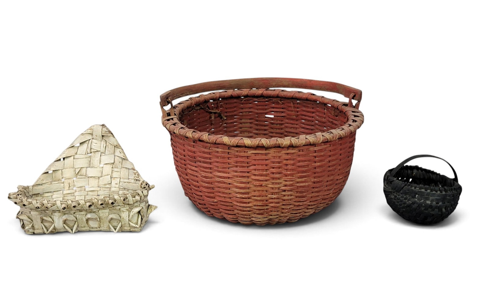 TRIO OF PAINTED AMERICAN BASKETS: Late 19th-early 20th century. A swing-handled basket in original red, 16.5" diameter; a wall pocket basket in original white, 10.25" wide; and a small round basket in old black, 6" diameter.