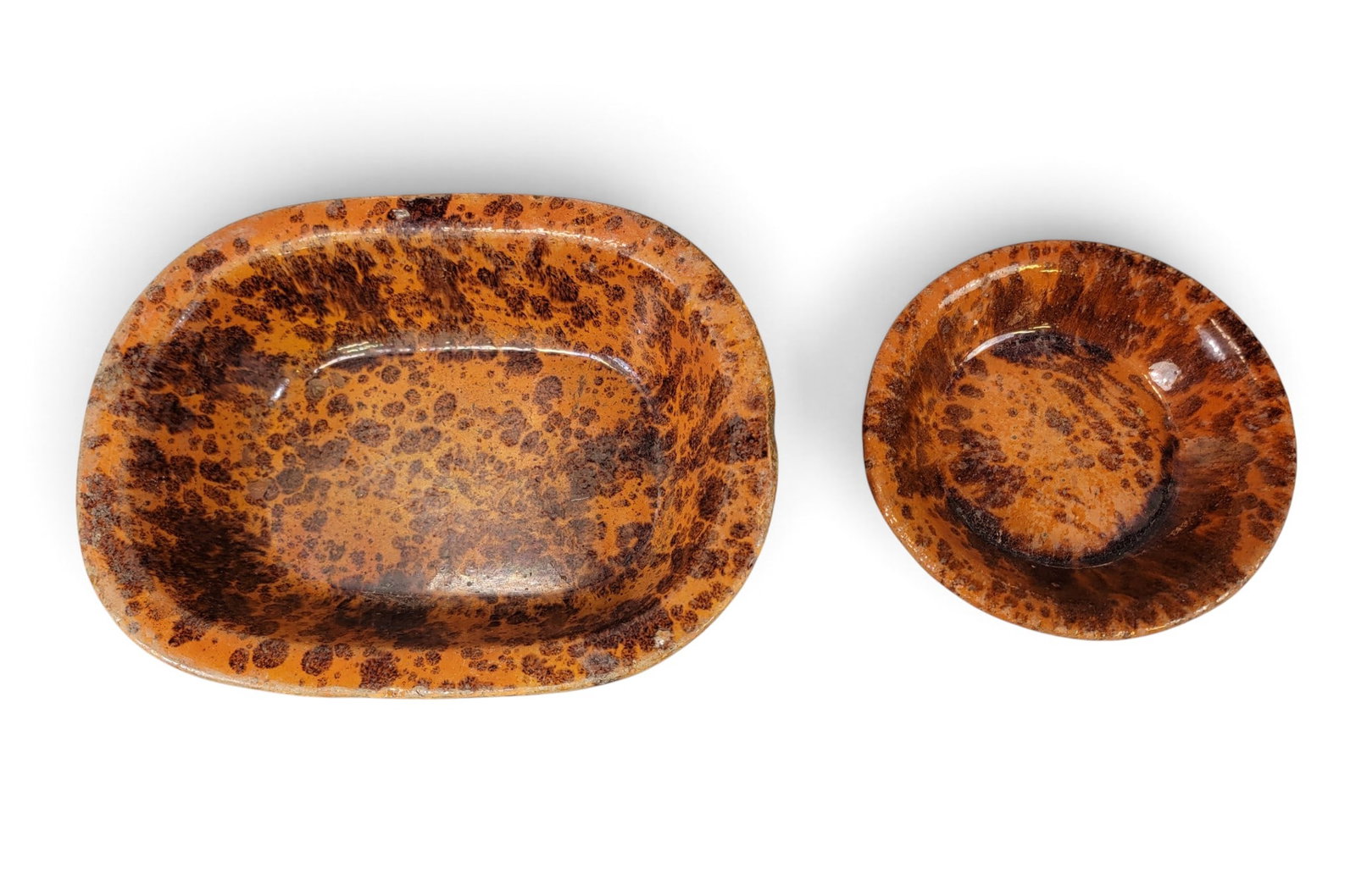 TWO AMERICAN REDWARE DISHES: 19th century. With dripped manganese glaze. 8.75" diameter and 13" by 10.25". Provenance: a New York State collection NOTE: We are happy to answer questions and take additional photos of lots prior