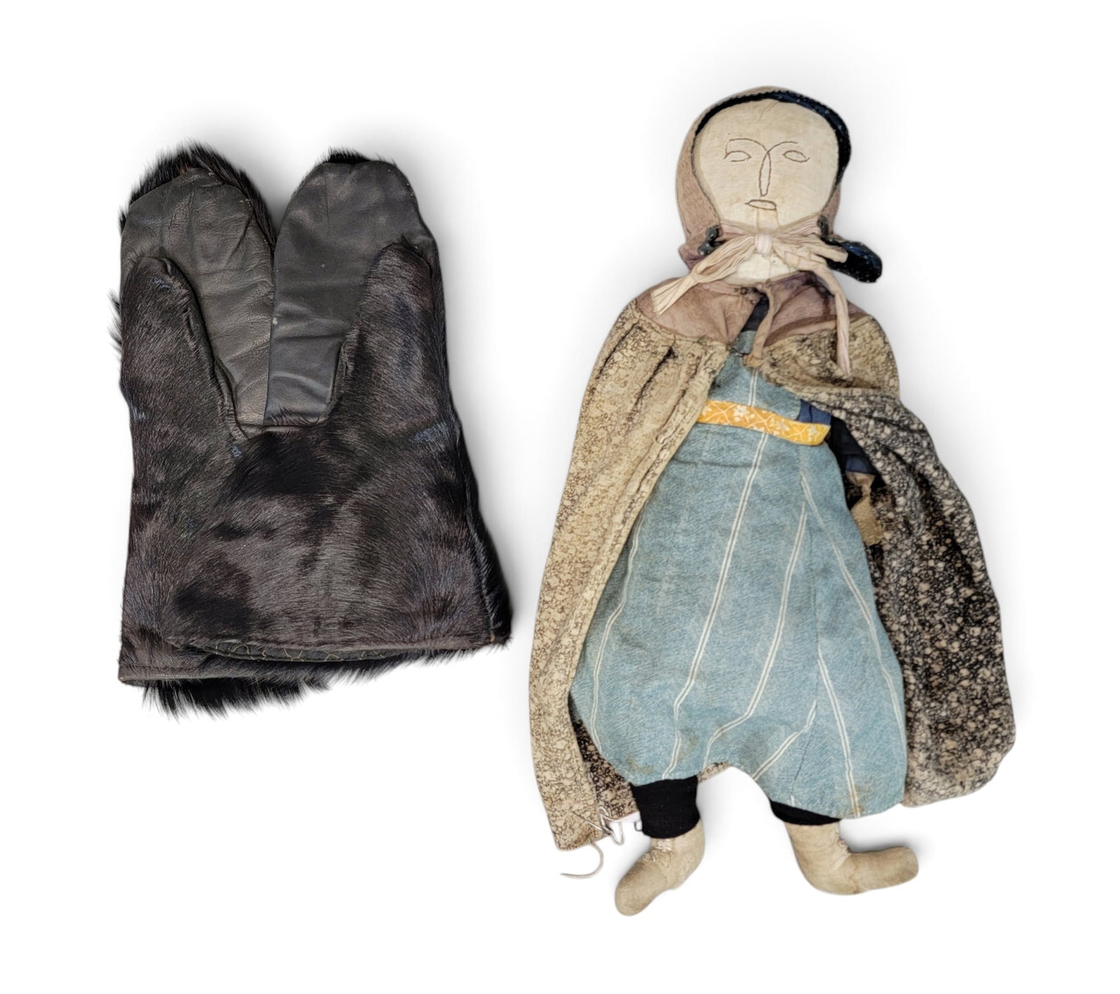 EARLY DOLL AND BEARSKIN MITTENS: American, 19th-20th century. Includes a possibly Amish/Mennonite cloth doll with original clothing, 21" long; together with a pair of bearskin mittens, 14" long. Provenance: a western New York