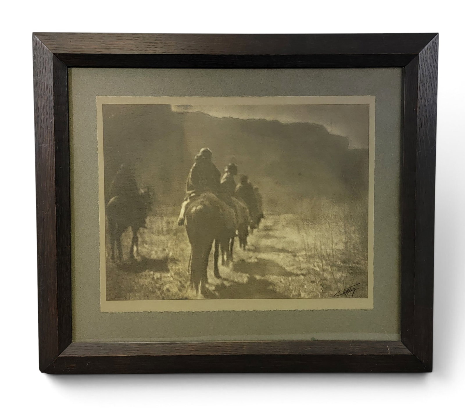 EDWARD S. CURTIS (1868-1952) PHOTOGRAPH: THE VANISHING RACE: Platimum print, 1904, signed in the print lower right, stamped EC1904 lower left. View of a line of mounted Navajo riding into the mountains. 12.125" high, 16.375" wide (print), in its original fumed 