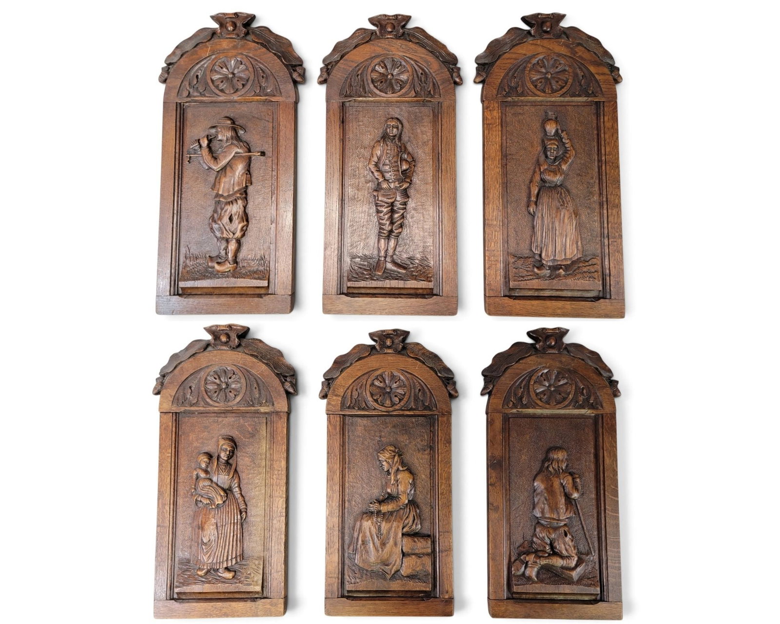 SET OF SIX CARVED PLAQUES: 19th century, oak. Arch-top panels topped by oak leaves and acorns, and each carved with a figure in high relief. 22" high, 11" wide. Provenance: a Pennsylvania collection. NOTE: We are happy to