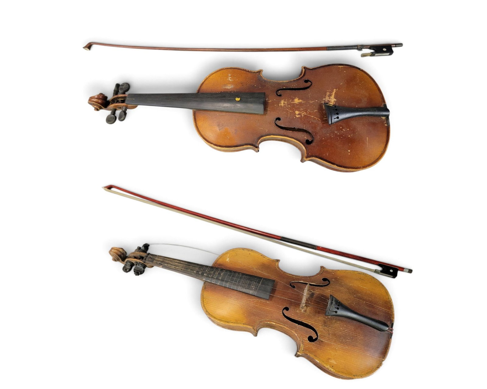 TWO STRADIVARIUS COPY VIOLINS: Late 19th-early 20th century. Both are unlabeled, one has Wilson's Appliable Fingerboard overlay (by Charles Himmelman Co.). Both are 14" body and 23.5" overall, and both have a bow and a case.