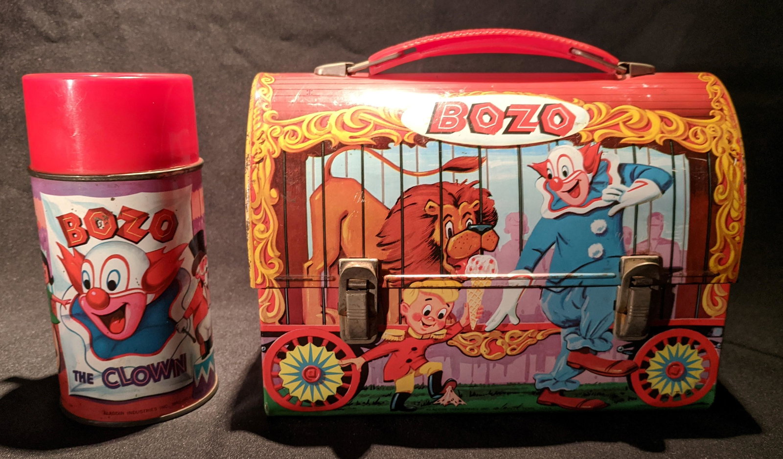 1963 BOZO the Clown Domed LUNCHBOX & Thermos by Aladdin: Vintage Domed Metal Lunch Box features great images of the famous BOZO the Clown and friends from the circus engaged in antics and adventures. Includes colorful Themo Bottle with original cup lid. Lic