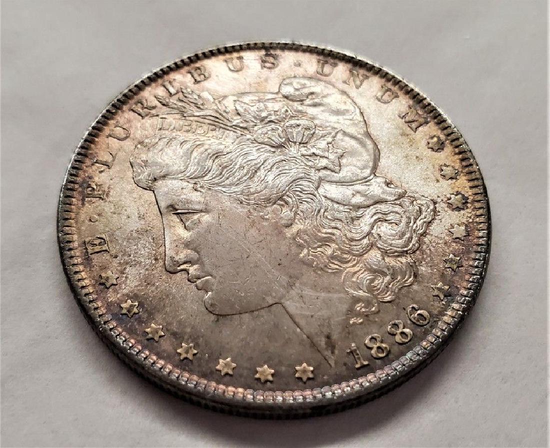 1886-P MS65 PL MORGAN SILVER DOLLAR: 1886-P MS65 PL MORGAN SILVER DOLLAR THIS IS A PL COIN WITH A HINT OF IRIDESCENT BEAUTIFUL ARIZONA SUNSET COLORING CREEPING IN ON THE EDGES. WINNER SHALL RECEIVE EXACT COIN SHOWN.