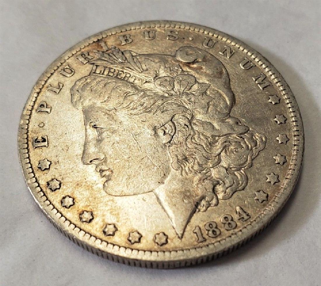 REALLY CRAPPY MORGAN SILVER DOLLAR 1884-0: IT'S BENT, IT'S DAMAGED, IT'S NOT ROUND. IT'S A HORRIBLE LOOKING COIN! BID WISELY ON THIS ONE. WINNER SHALL RECEIVE THE EXACT COIN SHOWN HERE.