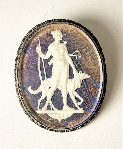 SPECTACULAR T.M. & CO. STERLING SILVER PIN: SPECTACULAR T.M. & CO. MADE IN ENGLAND STERLING SILVER PIN HAS AN INTERESTING REFLECTING BLUE BACKGROUND WHICH CHANGES SHADES WHEN TILTED A DIFFERENT DIRECTION, ALSO HAS A WOMAN WITH A BOW IN ONE HAND
