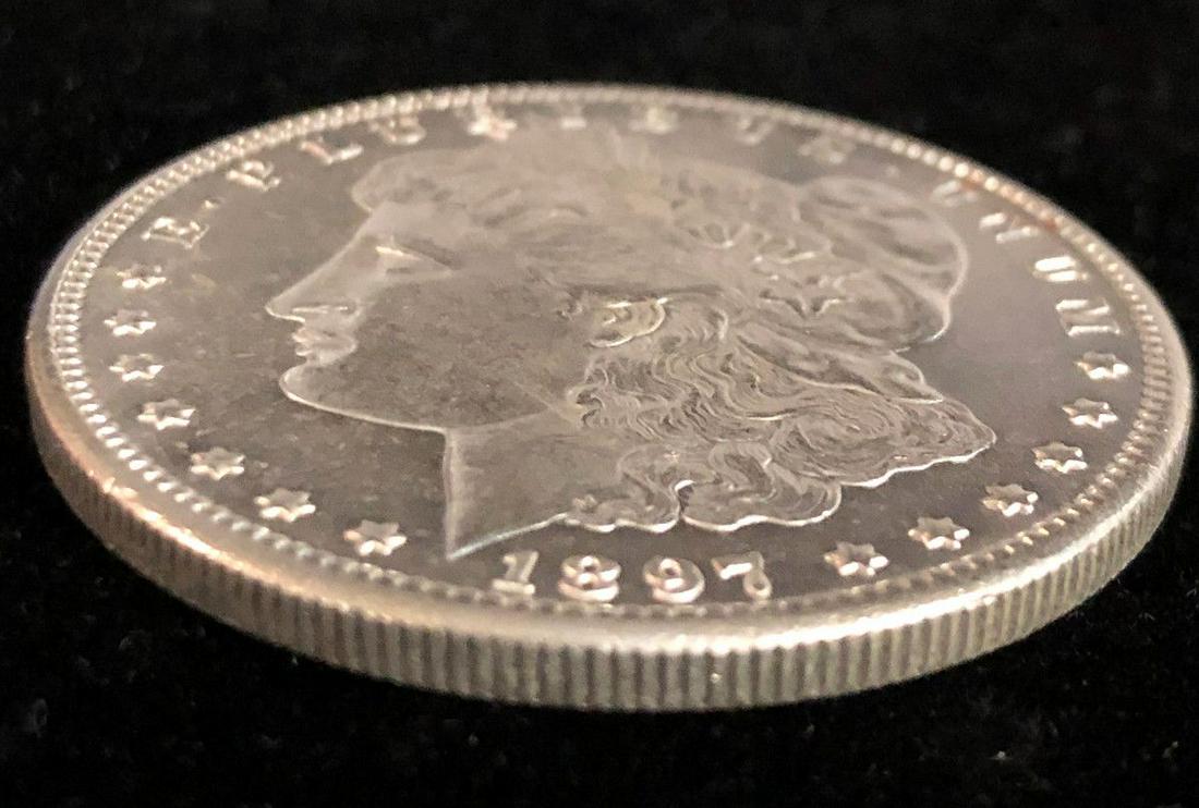 1897-S MORGAN SILVER DOLLAR AU55+: BACK AROUND 1986, I WAS A COIN DEALER WORKING FULL-TIME IN BEVERLY HILLS AT 8500 WILSHIRE BOULEVARD ON THE EIGHTH FLOOR. ONE OF THE MARKETING GUYS BROUGHT IN A CARD AND SAID "THIS OLD GUY HAS TOO MANY
