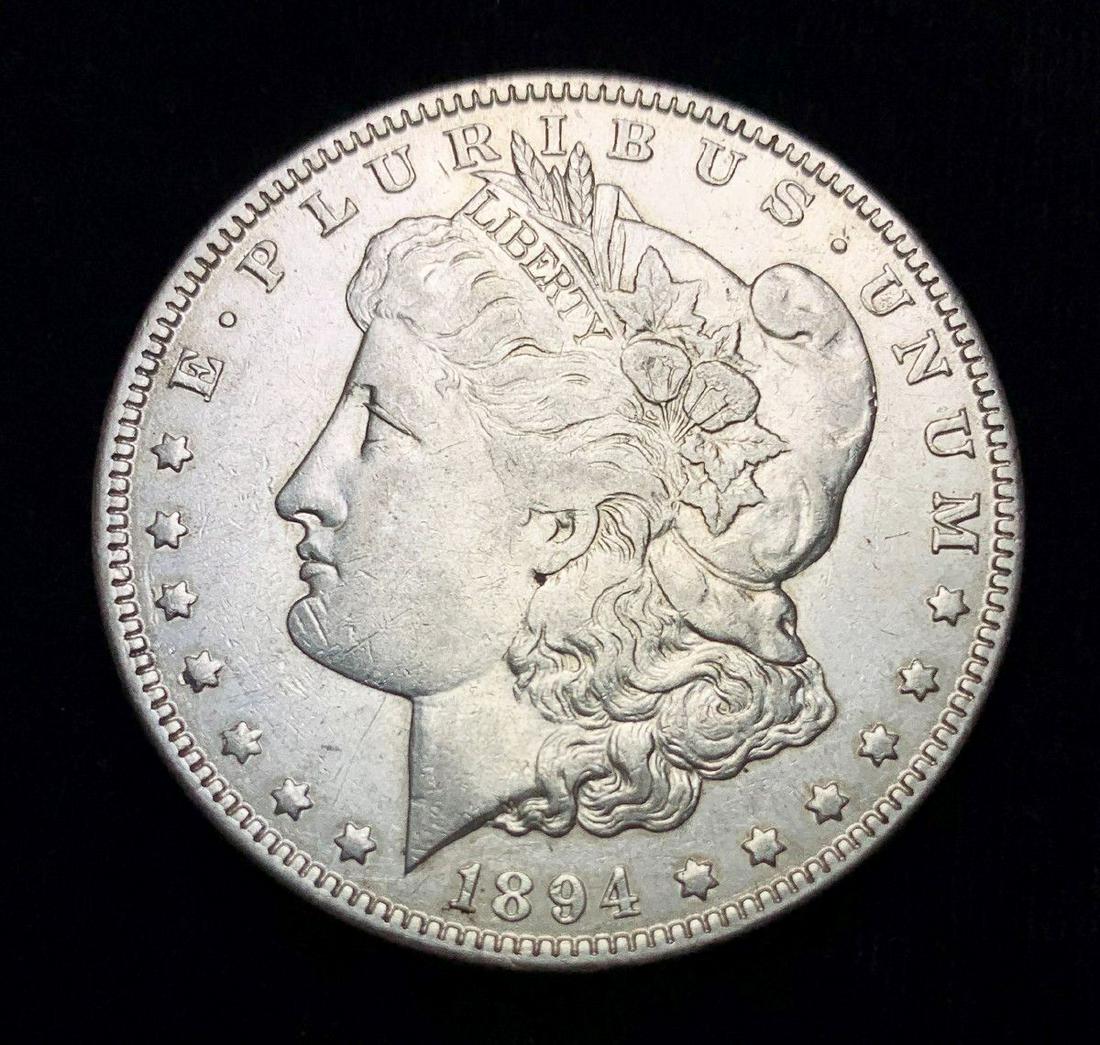 1894-O MORGAN SILVER DOLLAR AU CONDITION: BACK AROUND 1986, I WAS A COIN DEALER WORKING FULL-TIME IN BEVERLY HILLS AT 8500 WILSHIRE BOULEVARD ON THE EIGHTH FLOOR. ONE OF THE MARKETING GUYS BROUGHT IN A CARD AND SAID "THIS OLD GUY HAS TOO MANY