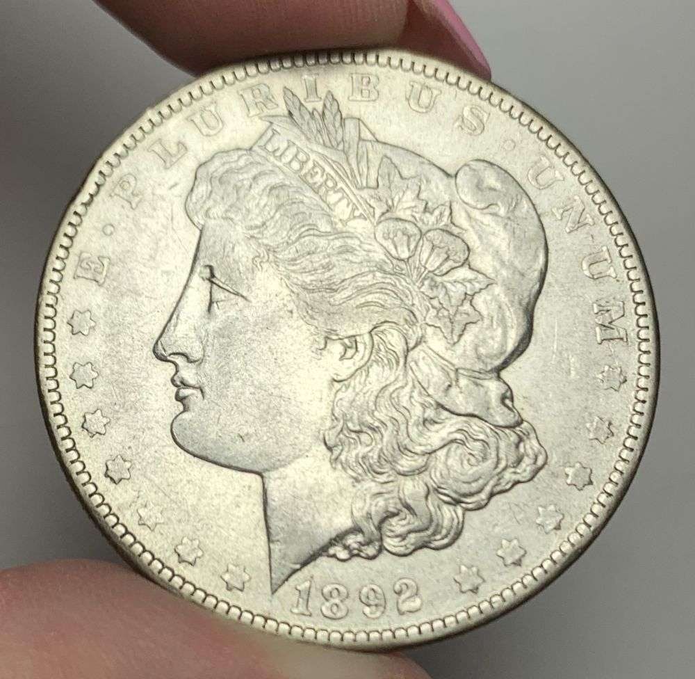 1892-O Morgan Silver Dollar AU55: This is (1) coin from a book that we received along with the heavy black book of silver dollars. Winner shall receive the exact coin shown here. (MR/PB)