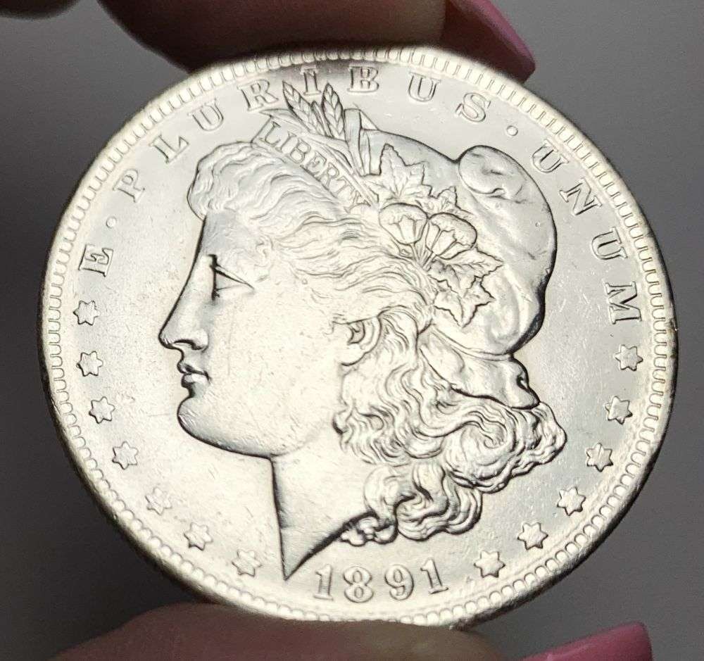 1891-O Morgan Silver Dollar AU58 Details: This is (1) coin from a book that we received along with the heavy black book of silver dollars. Winner shall receive the exact coin shown here. (MR/PB)