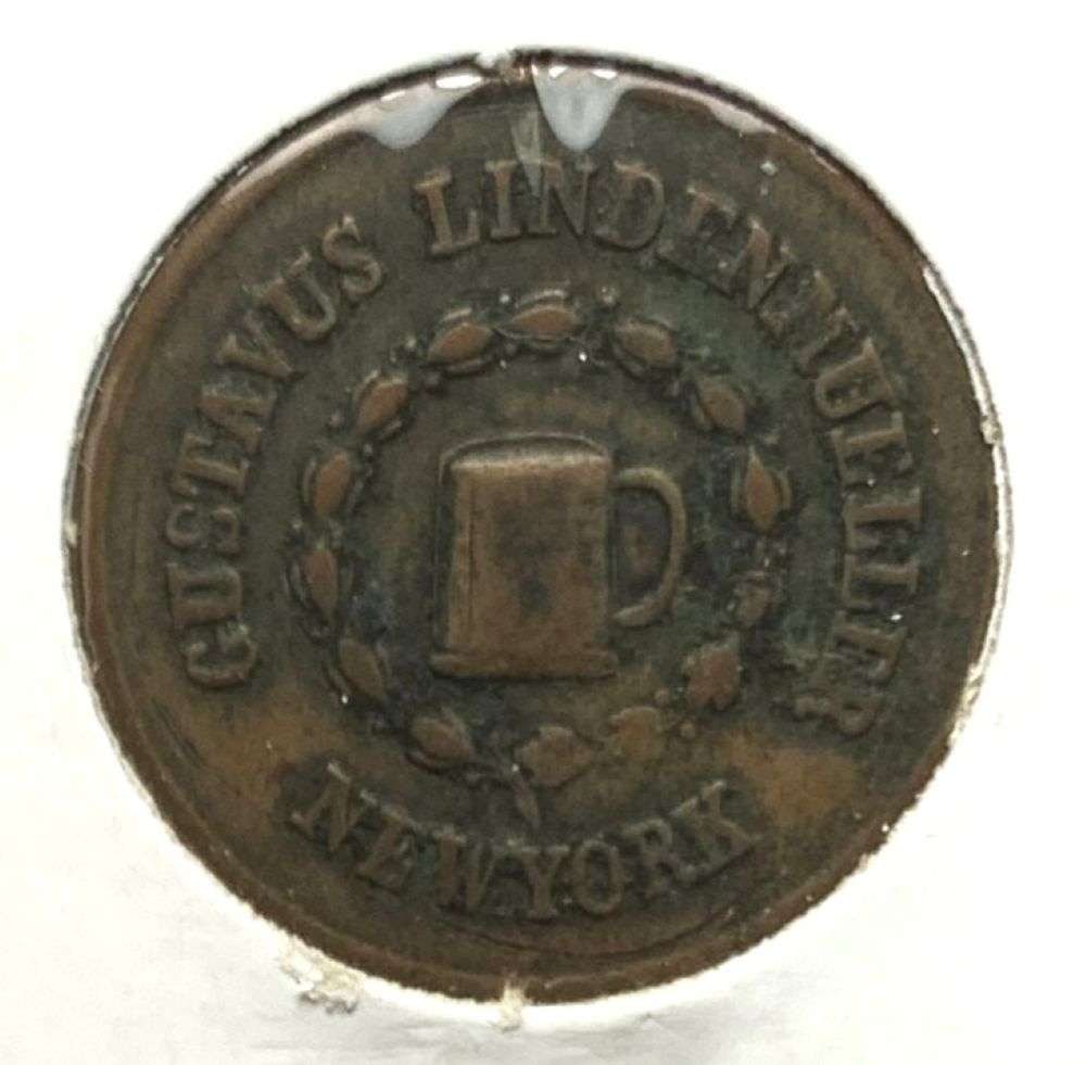 1863 Gustavus Lindenmueller Civil War Token: During the severe coin shortages of the Civil War, desperate merchants began minting unofficial copper "store cards" to keep commerce flowing. One of the most prolific was Gustavus Lindenmueller, a co