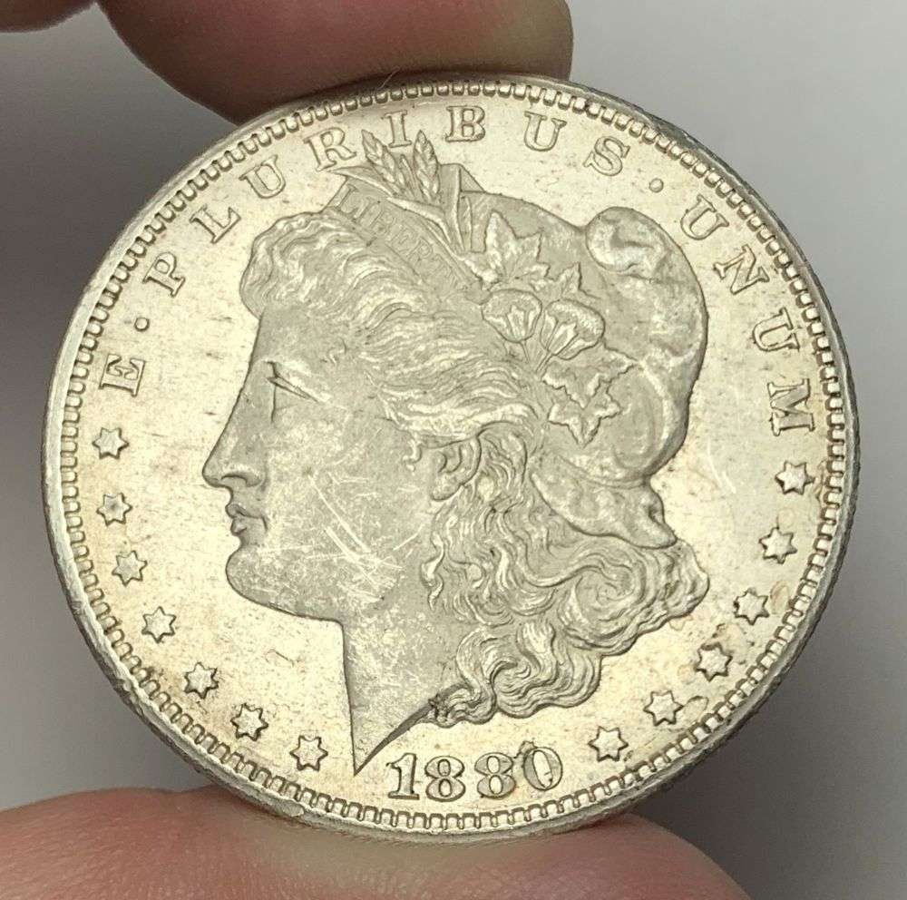 1880-CC Morgan Silver Dollar MS63 Details: This is the story about two coin dealers, a partnership. One, the largest bullion dealer north of San Francisco, and the other, the largest rare coin dealer north of San Francisco. Together, their sho