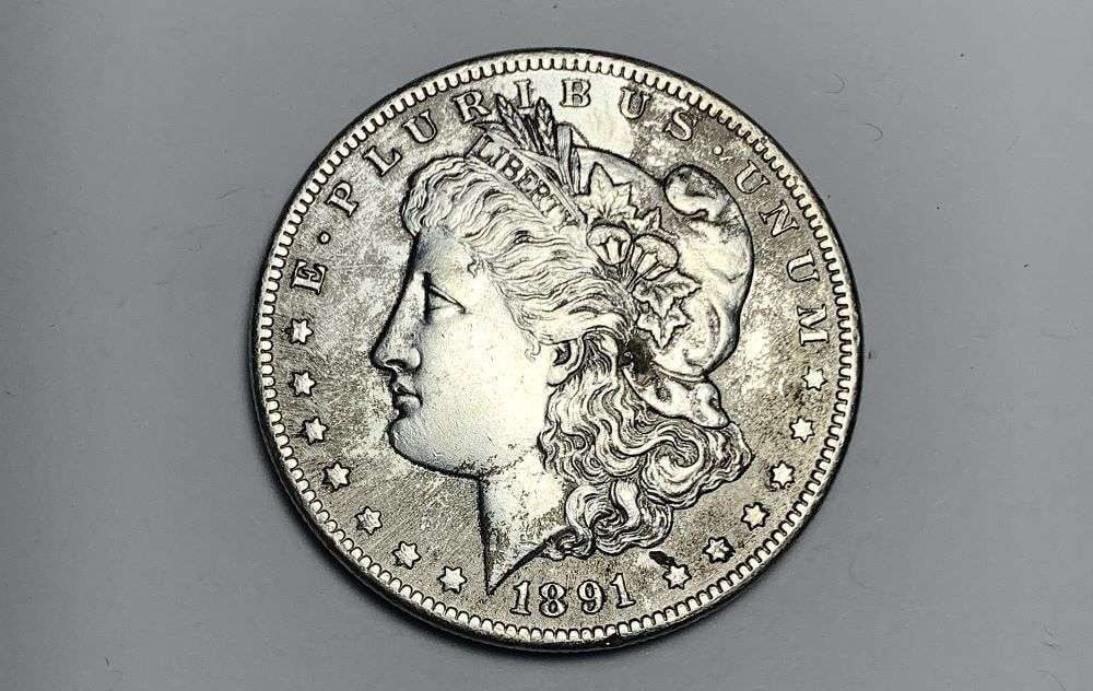 1891-CC Morgan Silver Dollar AU50 Details: This is the story about two coin dealers, a partnership. One, the largest bullion dealer north of San Francisco, and the other, the largest rare coin dealer north of San Francisco. Together, their sho