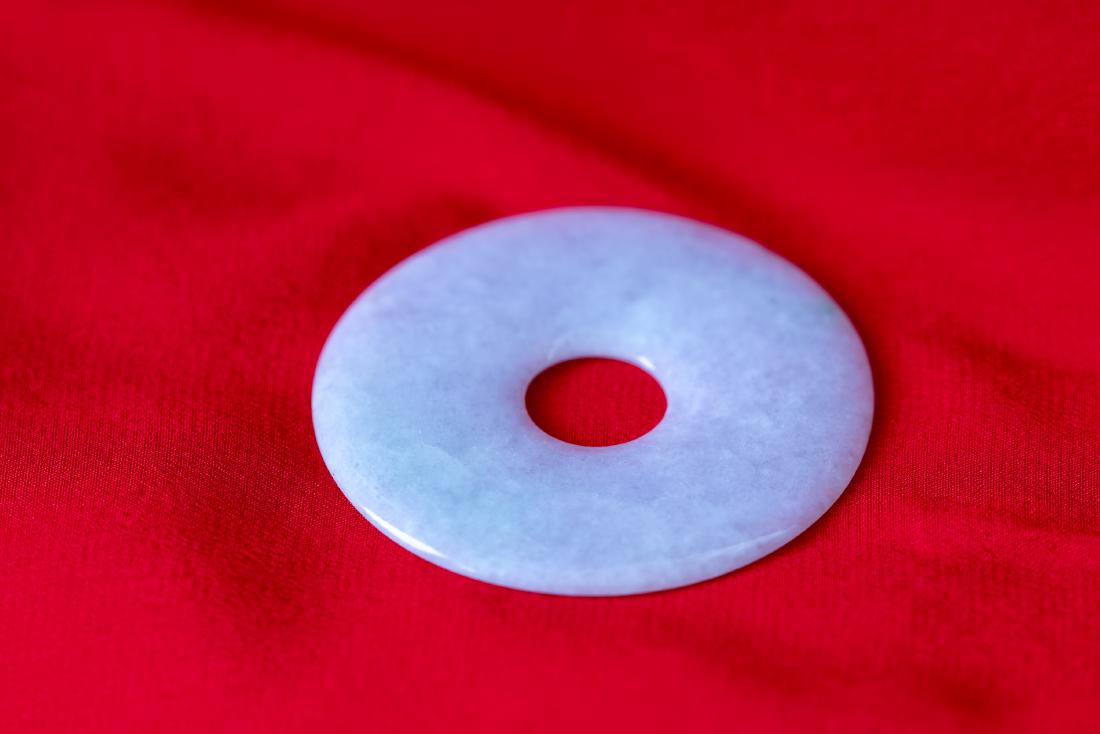 White Jadeite Bi, with Few Stops of Greenish Color.: More images will be ready before May 15. Estimate: $200 - $400. The surface is very smooth, the diameter is 2", with a hole of 0.5" in the middle. The thickness is about 3.5mm, the edge is about sligh