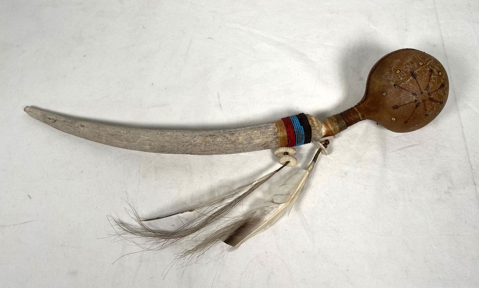 Native American Ceremonial Rattle with Stag or Bone and Feather: Antique Native American Indian Ceremonial Beaded Rattle with a Deer Antler or Stag Handle Three Sections of circular pony beads hues of red blue and black two large hanging Turkey Feathers with folded