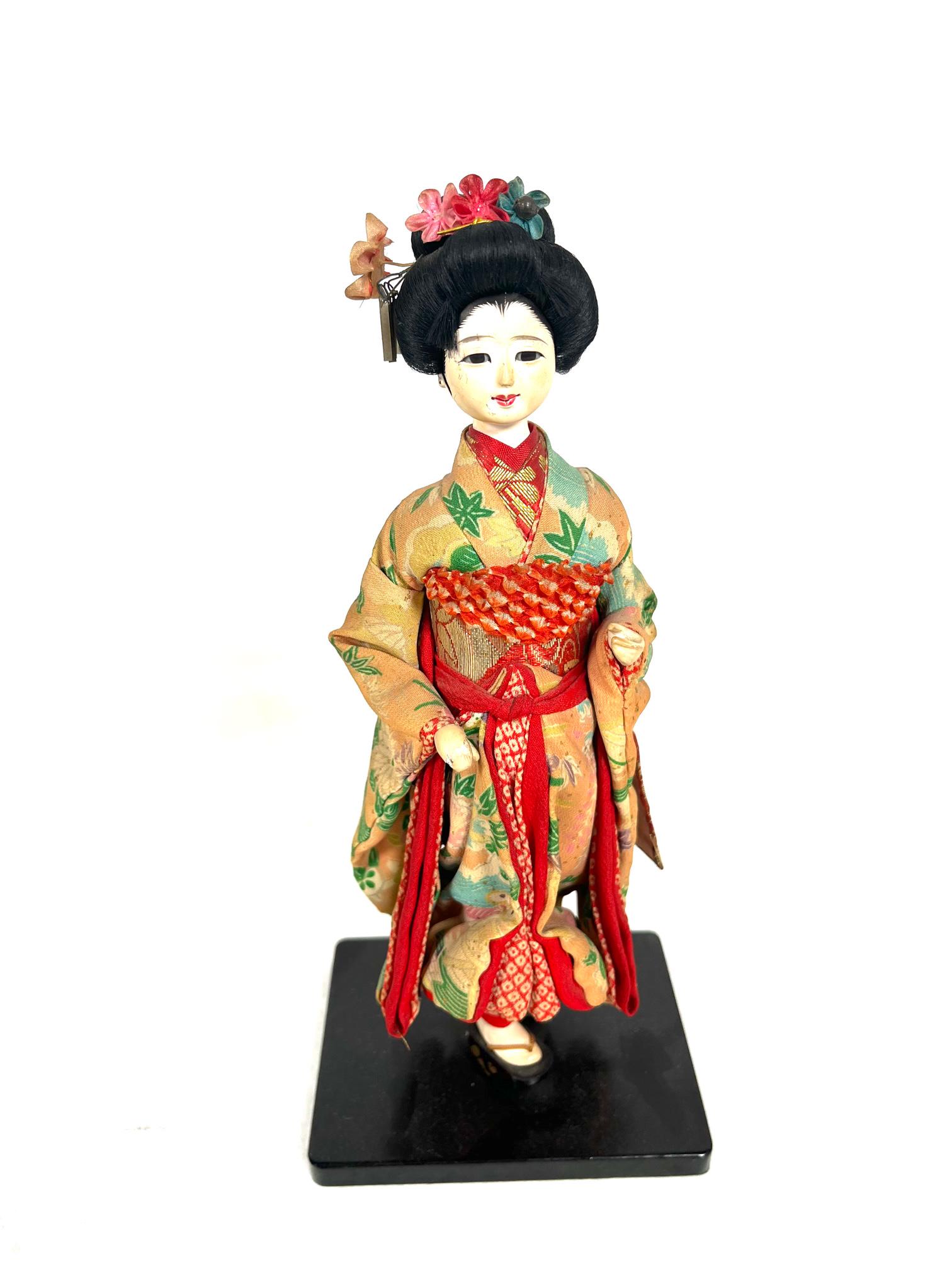 Japanese Silk Geisha Girl Sculpture: Japanese Geisha Lady Silk and Paper Mache ? Sculpture Figurine in Traditinal Kimono wearing wooden shoes boots or sandals on Black Painted Wooden Base in Good Vintage Condition 11" tall Out of New Yor