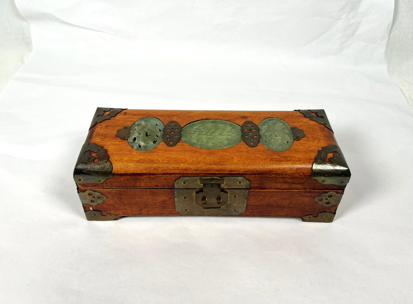 Antique Chinese Wooden Jade & Brass Scholar Box: Chinese Brass Mounted Wooden Jewelry Box with Jade Inlay Three Jade Medallions mounted Brass Fittings Interior is lined with Pink Silk Floral Motif Music Box Winder on Bottom 10" L x 3" H in Good Cond