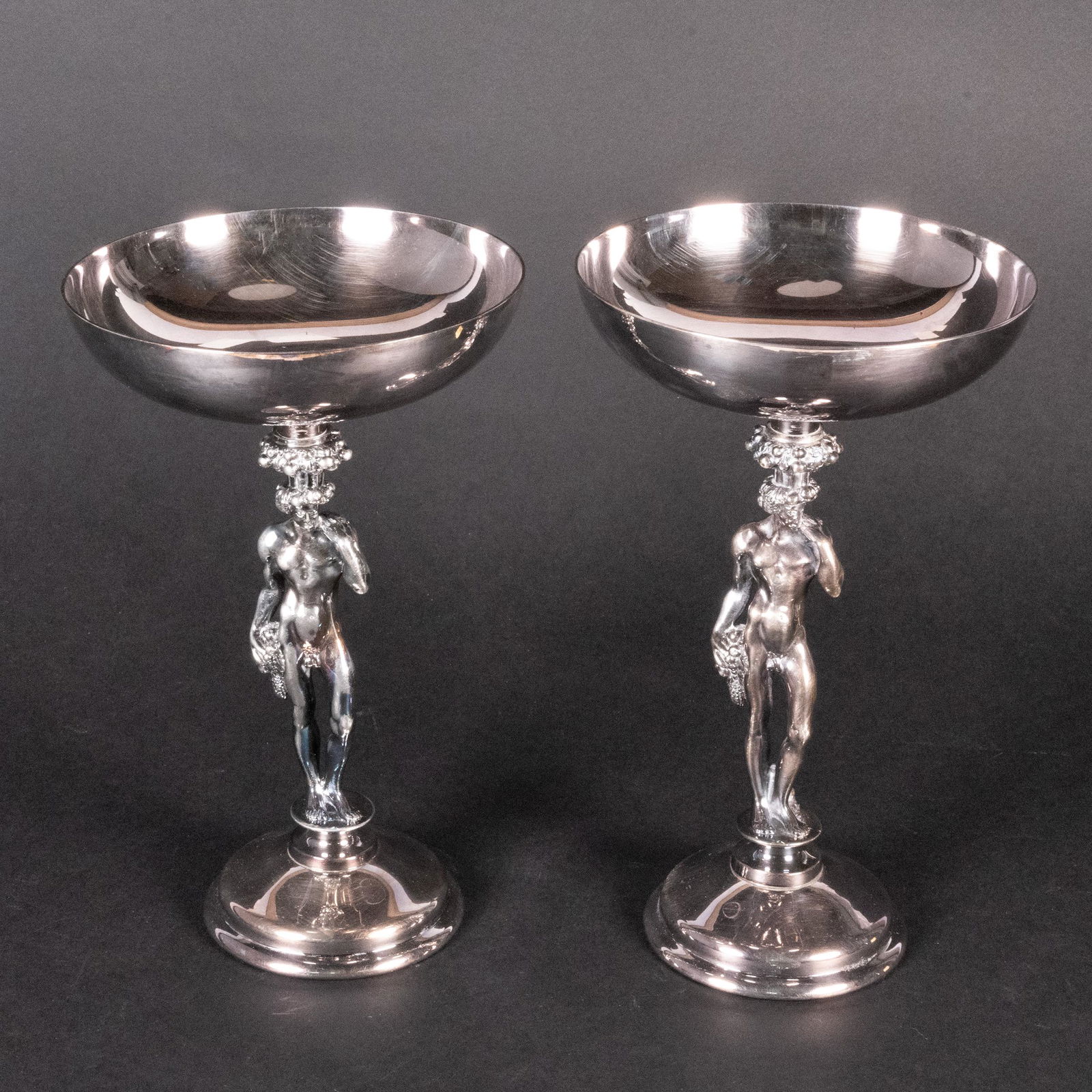 Christofle Silver Plated Figural Footed Compote Pair: Art Deco French Pair of Christofle Silver Plated Figural Semi Nude Male Compote Stamped Underneath " Christofle France ", features a hemispherical bowl over the Bacchic standard 8 1/4"H x 5" W In Over