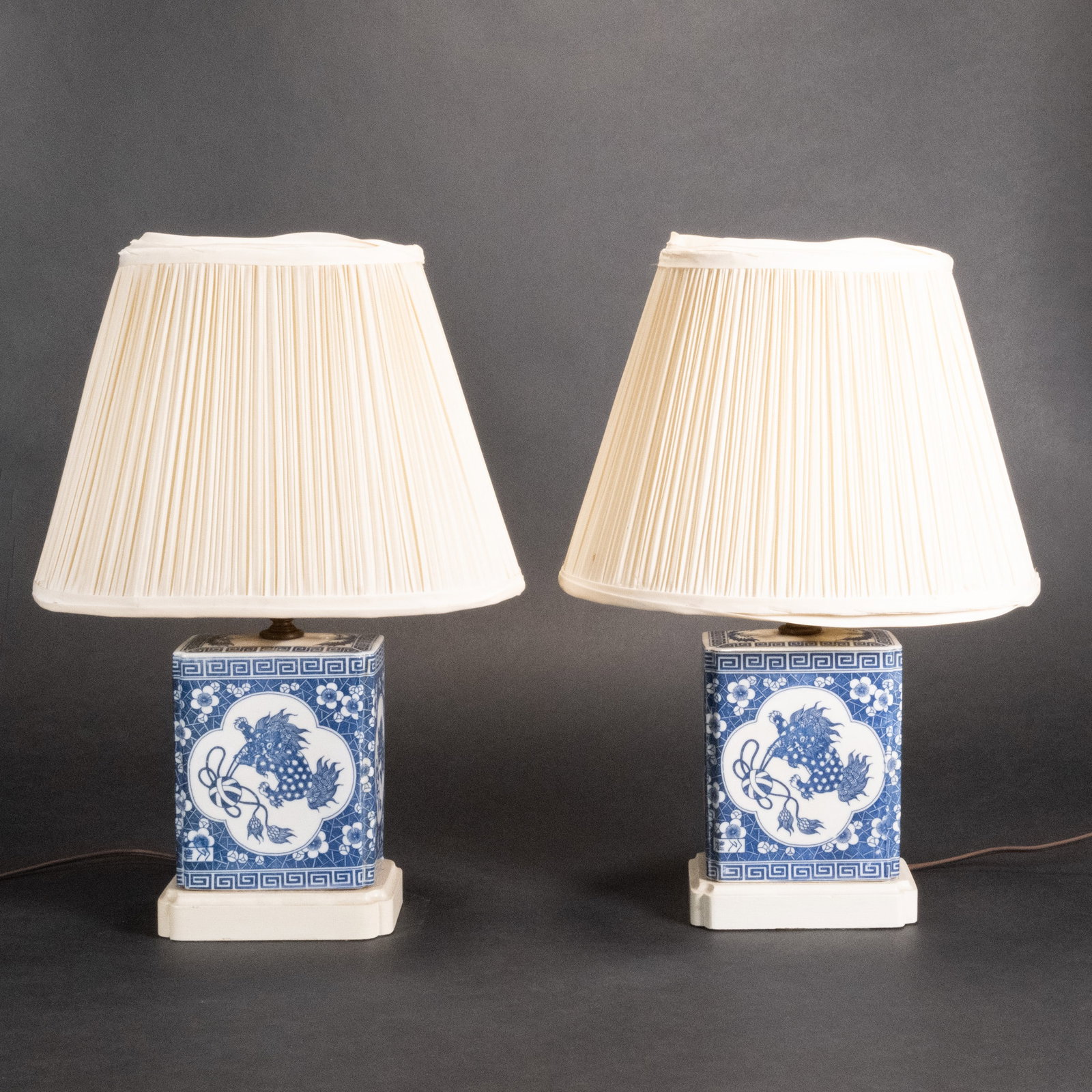 Chinese Ceramic Foo Dog Mounted as Lamp Pair: Chinese Blue and White Glaze Porcelain Foo Lion Mounted as Table Lamps Pair Hand Painted Rectangular Floral Motif Mounted on Rectangular Base 16 3/4"H x Shade 8 5/8"H x Bottom of Shade 12"L x 8" W x T