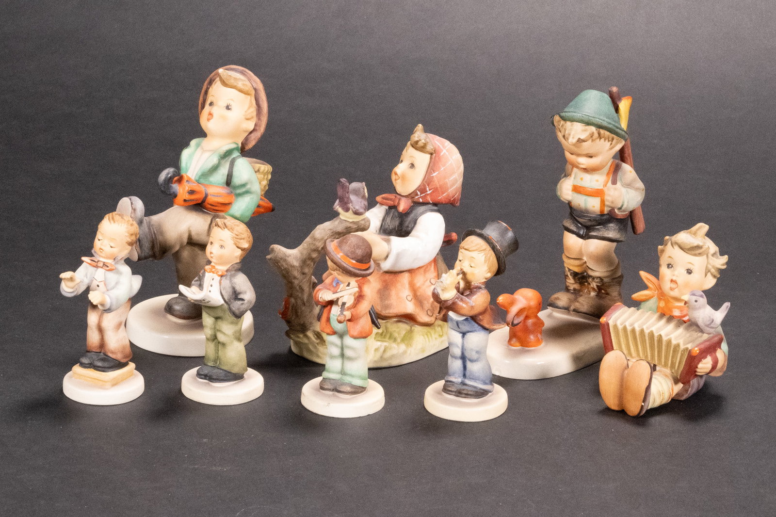 Large Hummel Sculpture Collection Lot: Large Hummel Sculpture Collection Lot (1) # 79 Globe Trotter (2) #4 14 In Tune (3) # 6//11 Sensitive Hunter (4) # 110 Let's Sing (5) #4 26 Little Fiddler (6) # 135 Soloist (7) # 85 Serenade (8) # 398 
