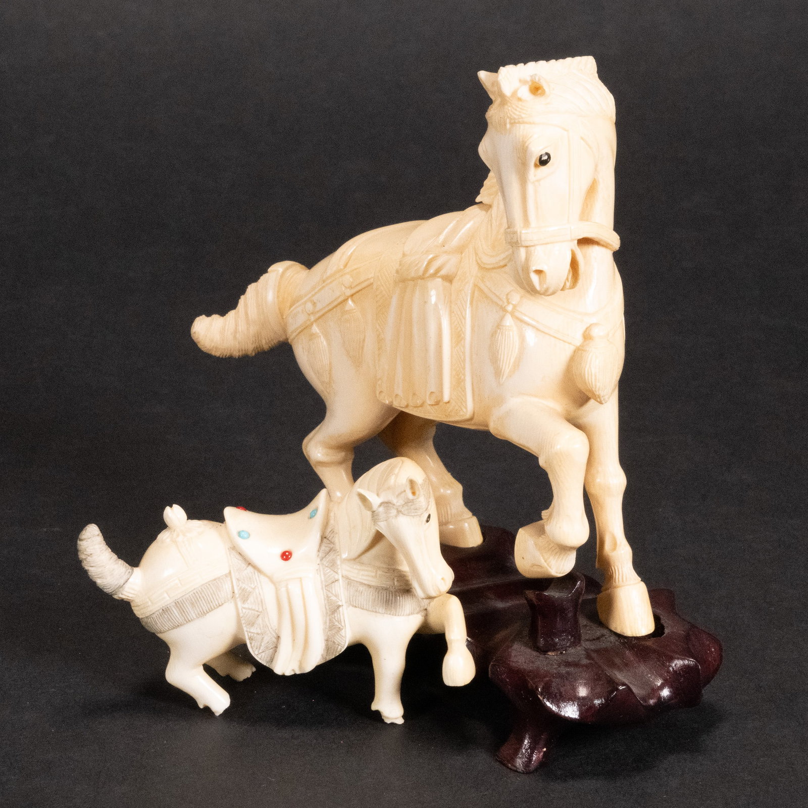 Chinese Tang Carved Horse Group Lot: Chinese Tang Hand Carved Horses First Horse is on a 6" x 5" x 2" On Dark Wooden Stand (Removable) Draped In A Saddle Blanket With A Parade Harness And Tied Back Tail The Second is Freestanding 3" x 1.