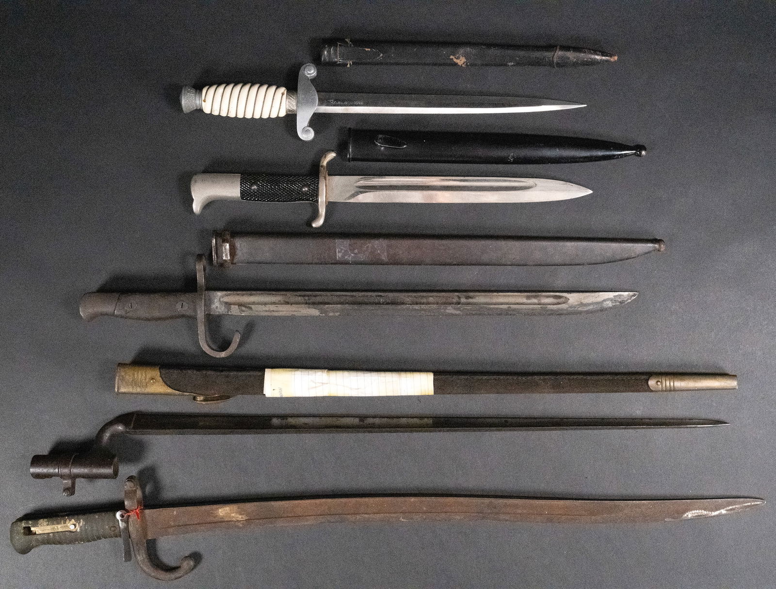19th/20th c. Sword Dagger Bayonet Collection: Revolutionary War Civil War WWI and WWII Short Swords Daggers Rifle Bayonets Collection Grouping Group Lot Consisting of (1x) WWII German Bayonet has a bright blade with sharp pointy tip Blade has som