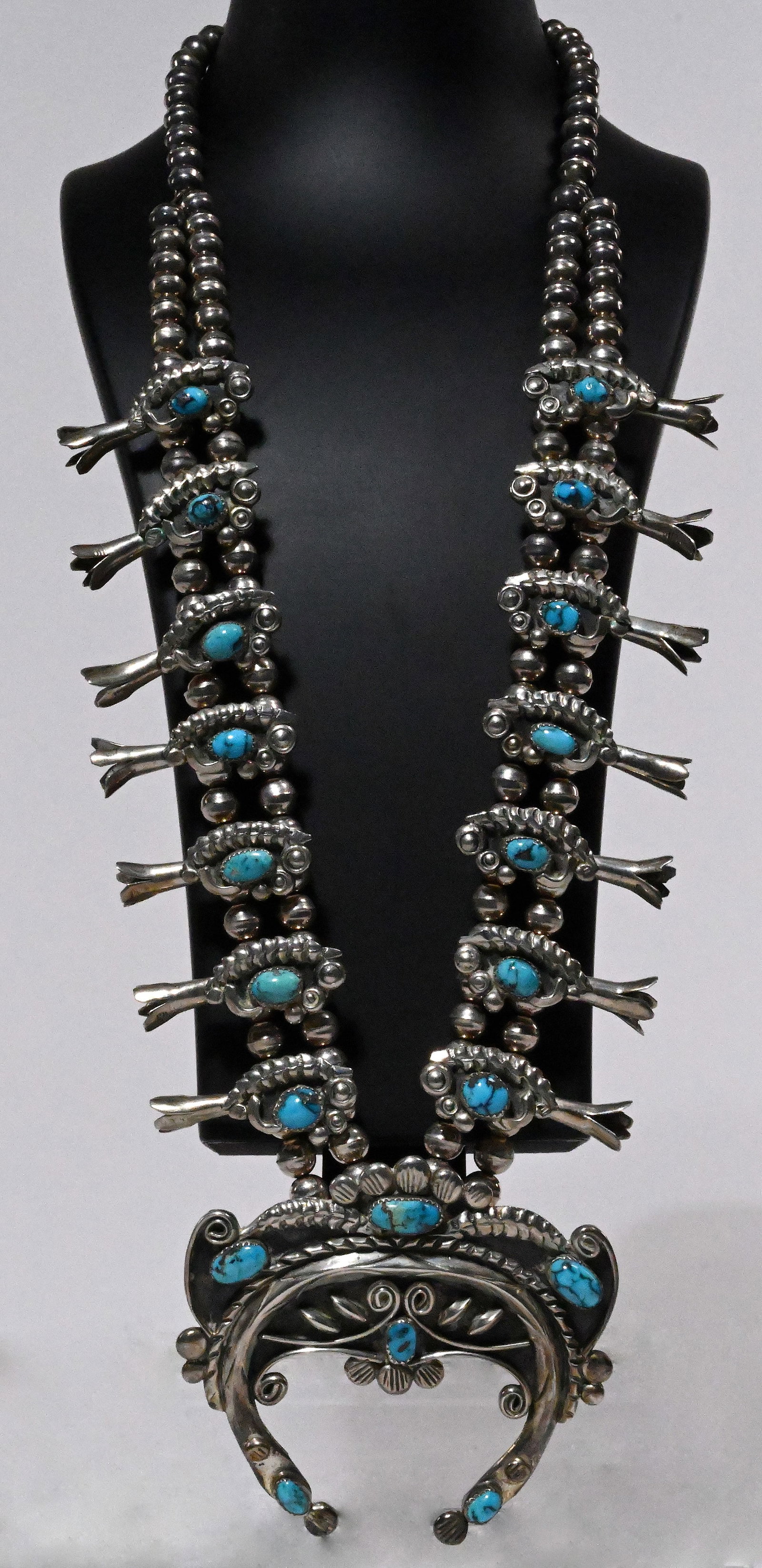 Navajo Native American Large Sterling Silver Kingman Turquoise Squash Blossom Necklace: Extremely Rare Hard to Find Navajo Tribe Native American Indian Large Sterling Silver Kingman Turquoise Squash Blossom Necklace Etched Foliage Scrolled Motif Accented with Sterling Silver Pearl Bead W