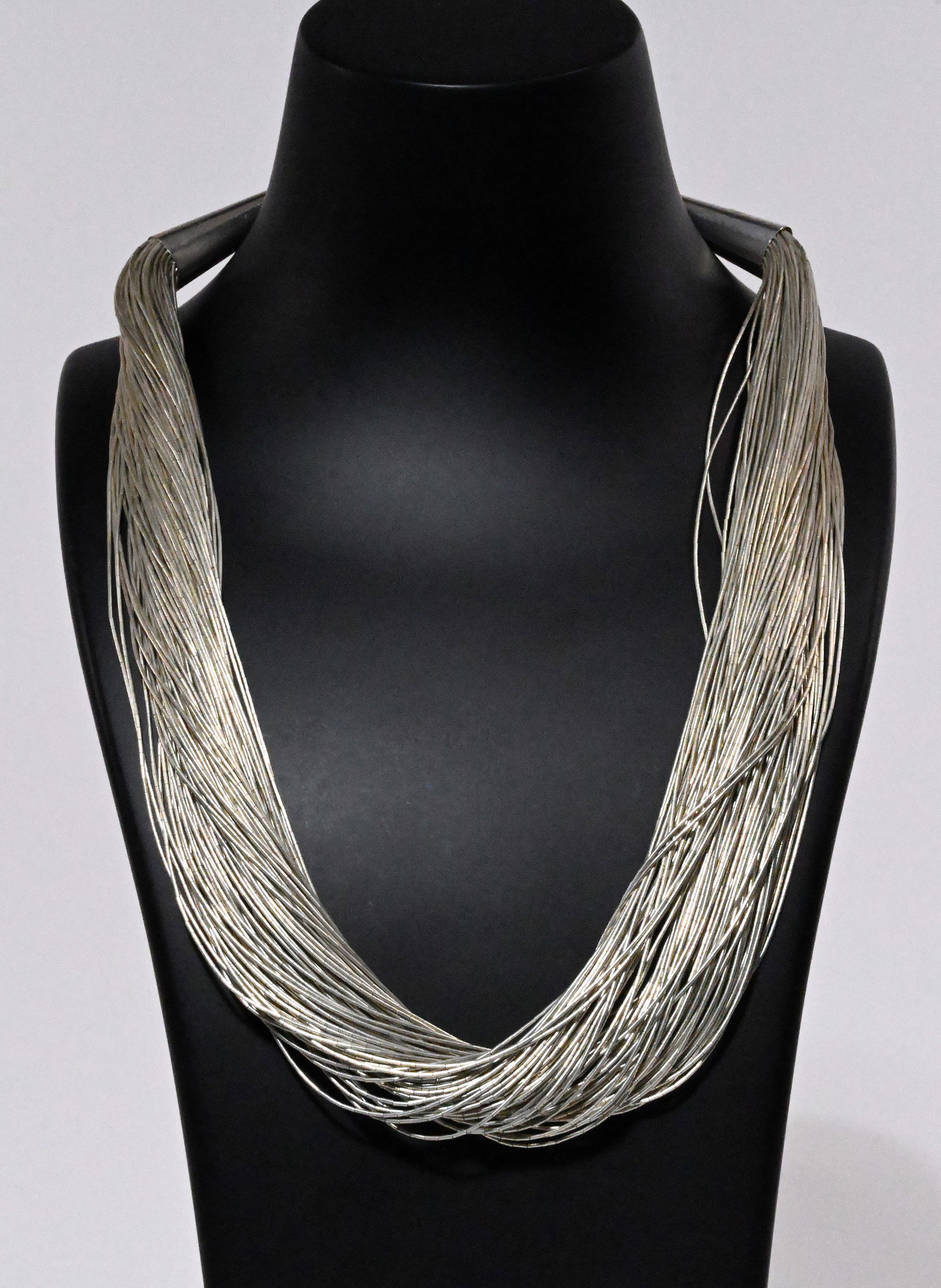Navajo Native American 102 Strands Liquid Sterling Silver Necklace: Navajo Tribe Native American Indian 102 Strands Liquid Sterling Silver Necklace with Hook and Eye Clasp Closure Hallmark to Each Cone Holding Strands: "Sterling" with Pictorial Hallmark of Rising Sun 
