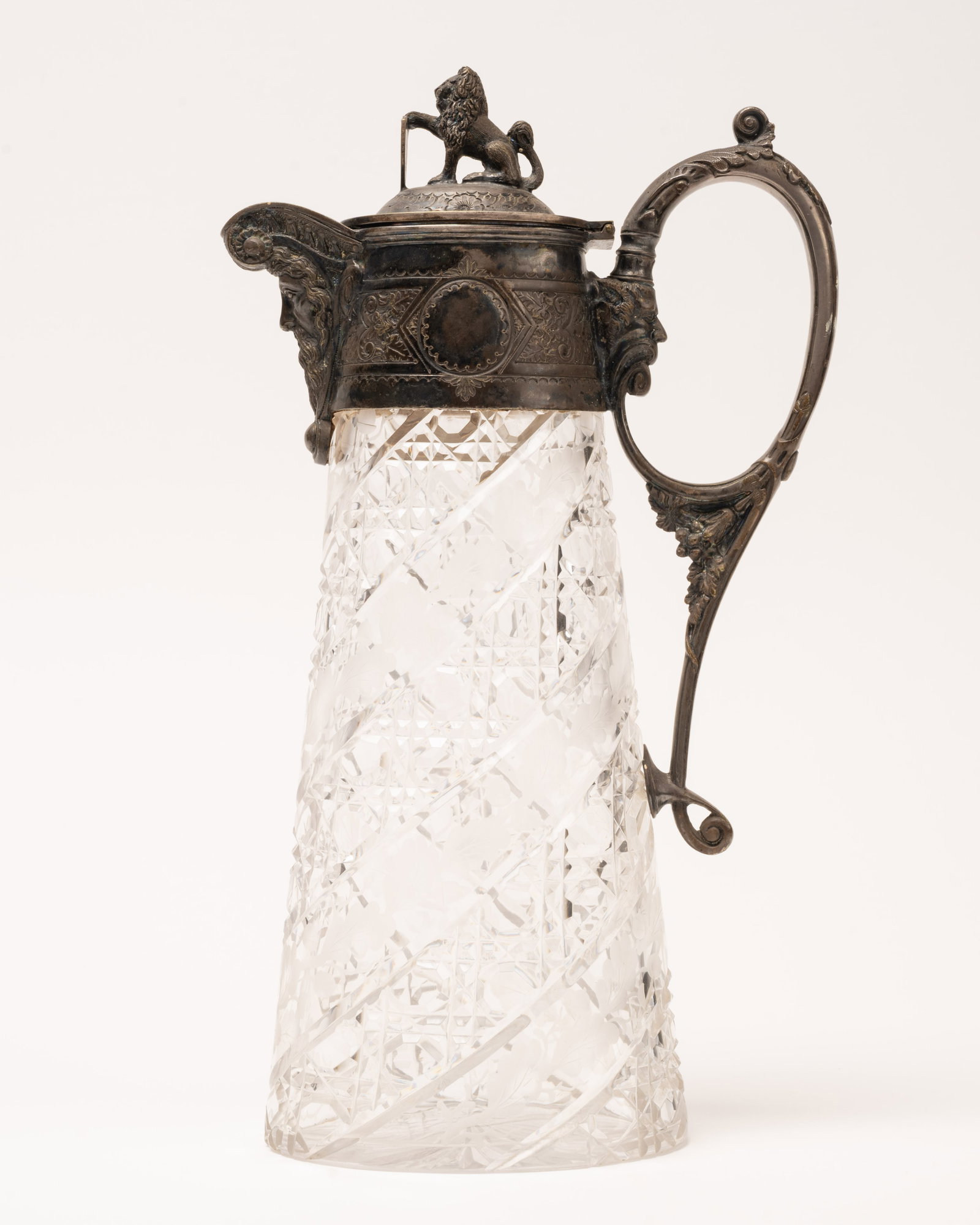 19th c. Victorian Cut Crystal Claret Ewer w/ Figural Mounts: 19th / 20th Century Victorian Cut Crystal Claret Jug Pitcher Multiple Figural Mounts Detailed Pirate Mask Spout Lion Finial and Additional Mask Handle Detail Cut Crystal Body Spiral Geometric