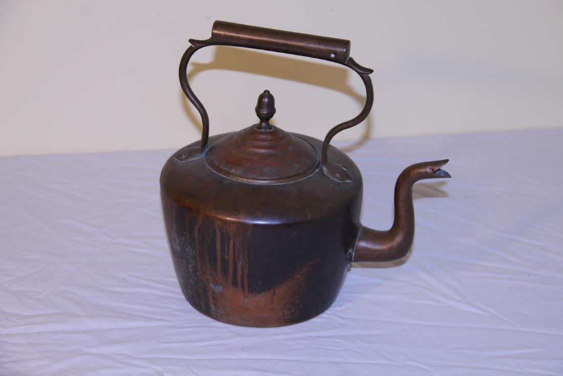 Early copper teapot: This nice vintage copper teapot measures 12” T and has shaped spout in front. Shaped copper handle on top. The bottom is getting thin from use and there is a tiny hole in the back of the bottom.