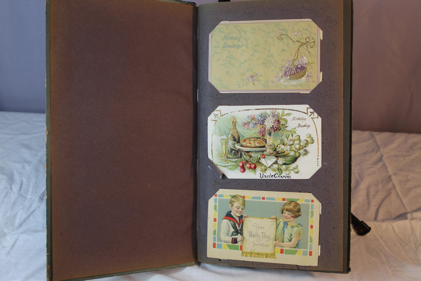 Album full of antique postcards: This lot includes birthday greetings, holiday themed and more postcards. This has over 75 cards in this album. Most cards are in great overall condition, they have been stored in this album for quite