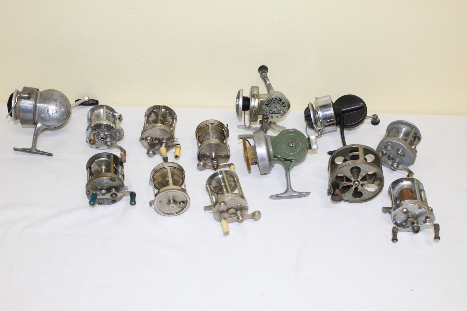 Lot of antique fishing reels: This lot includes 13 reels. Listed as: Bache Brown Spinster reel. Pflueger Akron no. 1893L reel. A. F. Meisselbach takapart 100 yard reel. Precision level winding reel etched dolphins on one end no ot
