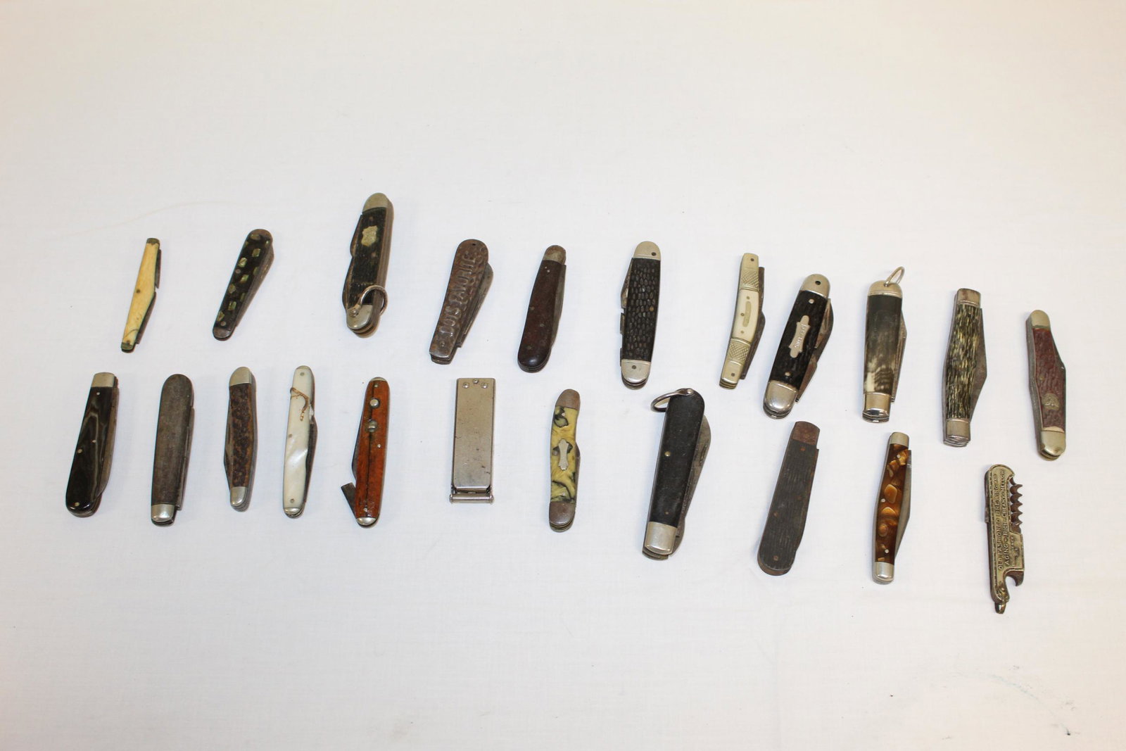 Lot of antique pocket knives: This lot includes about 22 pocket knives. Some are marked and others are not. The marked knives read Kamp â€“ King, Scout Knife, Midge PAT JAN. 7, 1913. Old fashioned brewing and aging rich cream