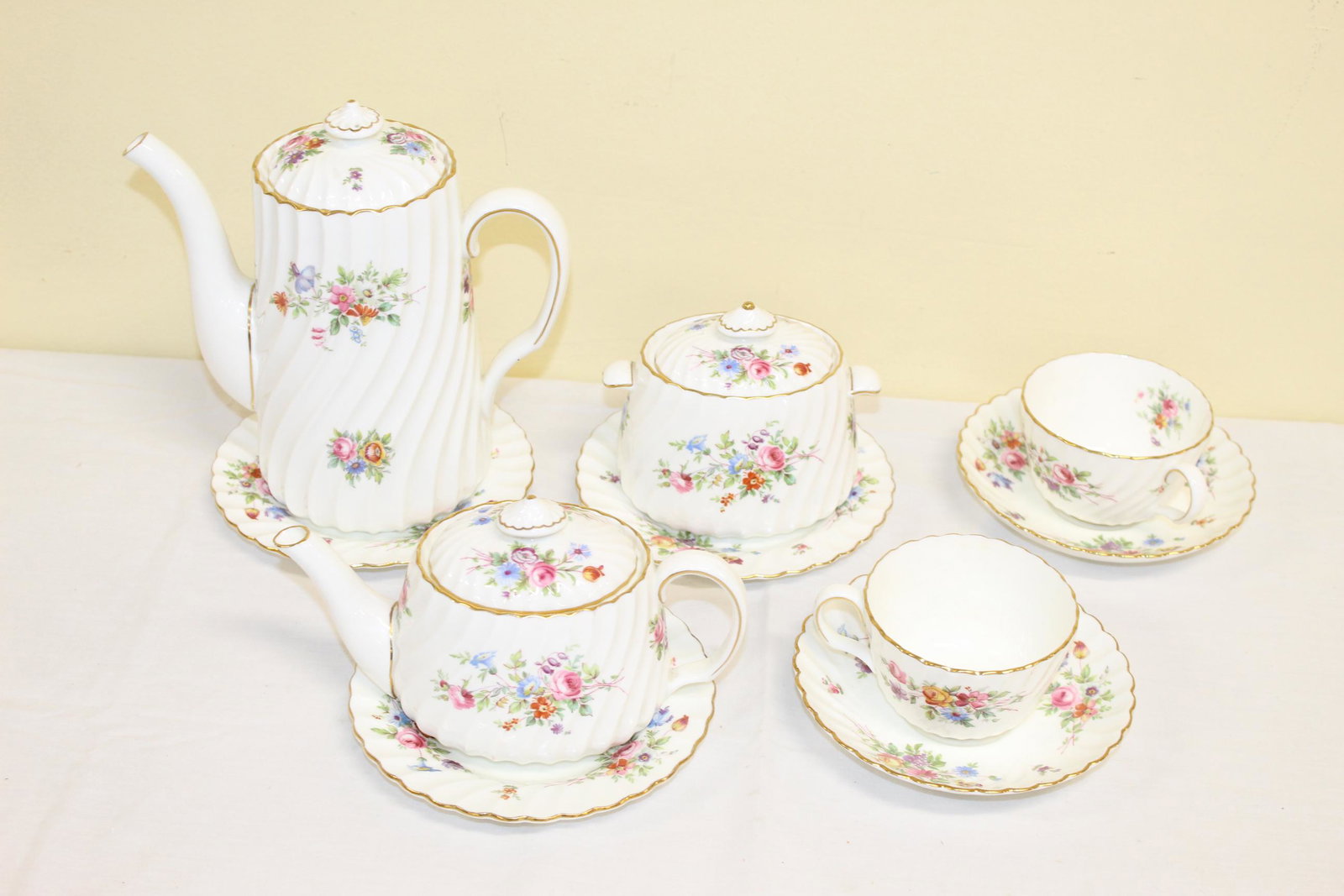 Mintons made in England tea for two china set: This beautiful set includes; sugar bowl with cover, creamer with cover, tea pitcher with cover, two tea cups with saucers and three small plates. These have the makers mark on bottom and reads MINTONS