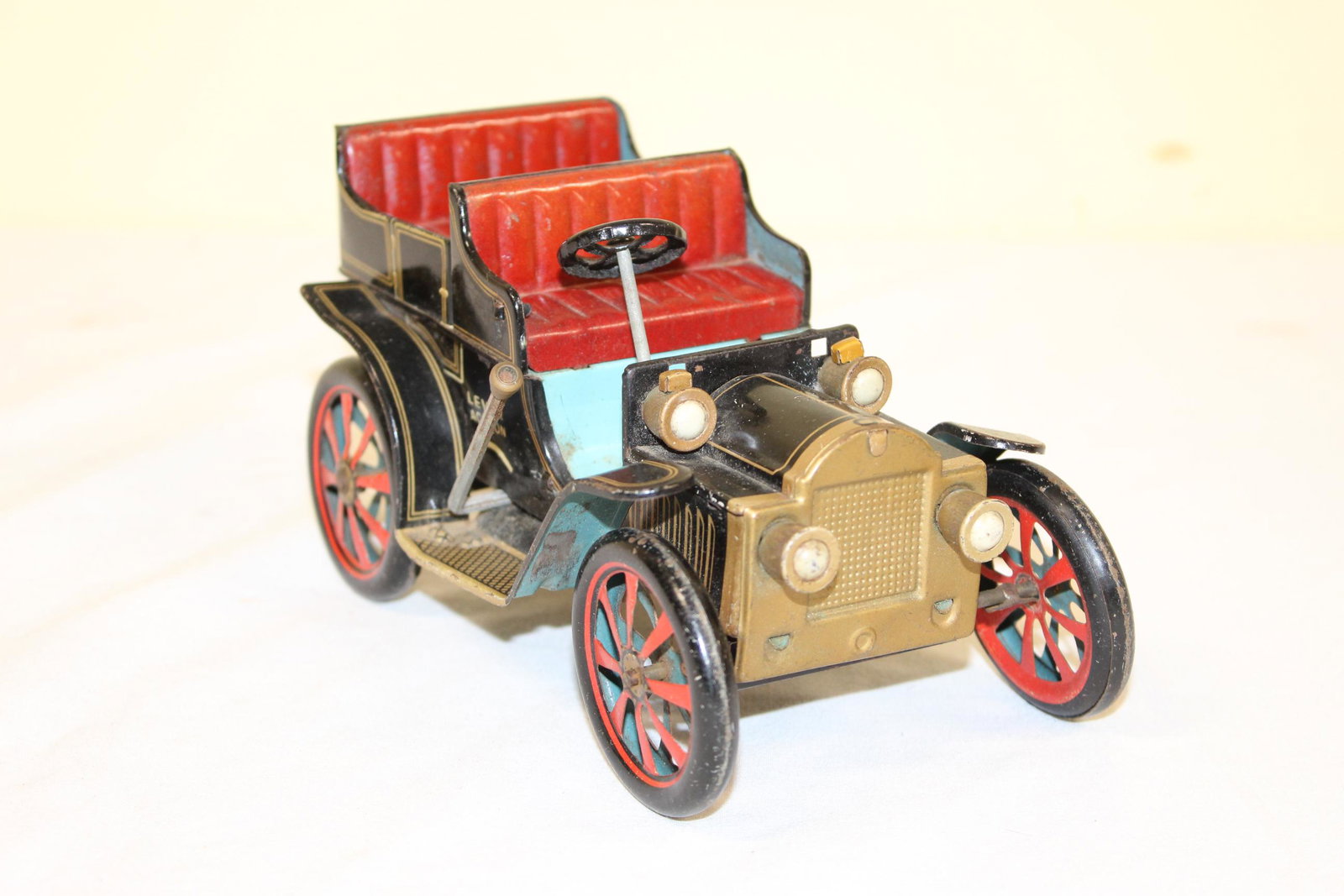 Vintage lever action tin toy car: This nice vintage tin toy car operates with a lever action that operates the back wheels so the car moves forward. Patent No. 27579 there are also some number underneath that 104210, 100166, 103627. M