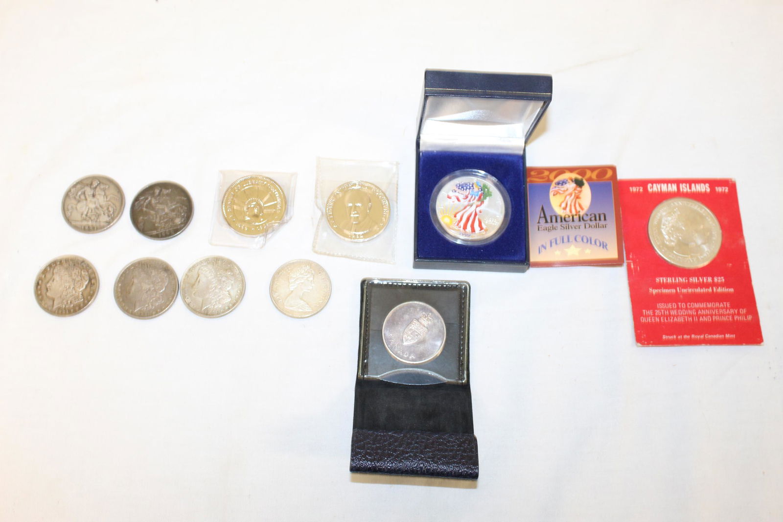 Lot of misc. coins: This lot includes; 2000 American eagle 1oz silver dollar in full color. 1972 Cayman Island sterling silver $25 issued to commemorate the 25 th anniversary of Queen Elizabeth II and Prince Philip. Stat