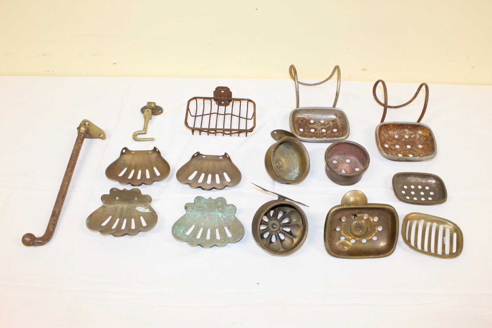 Lot of antique bathroom items: This lot includes about 12 different soap holders that can be attached to the wall. Item that appears to be a sink drain. Bar I assume for hanging wash cloth. There is a hook that can hang off the wal