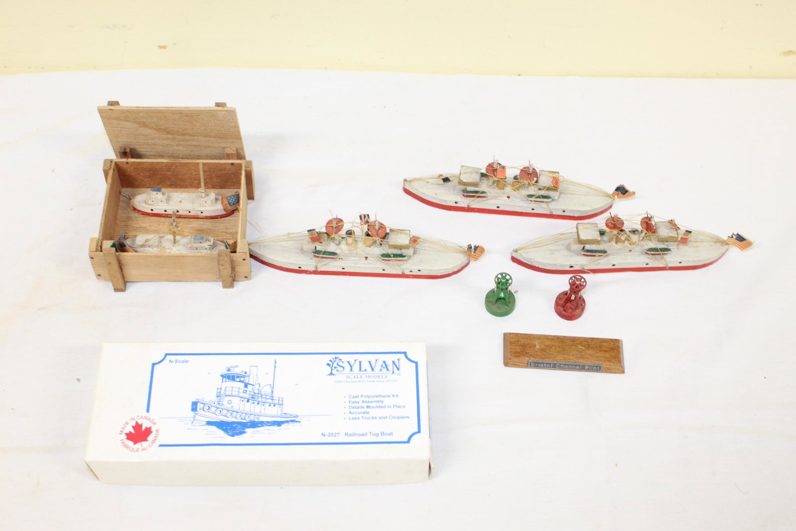 Lot of miniature boat models: This lot includes 3 identical boat models â€“ wooden â€“ measure 6.5in L x 1in W overall â€“ painted red,white and green â€“ have American flags on the backs â€“ the strings h