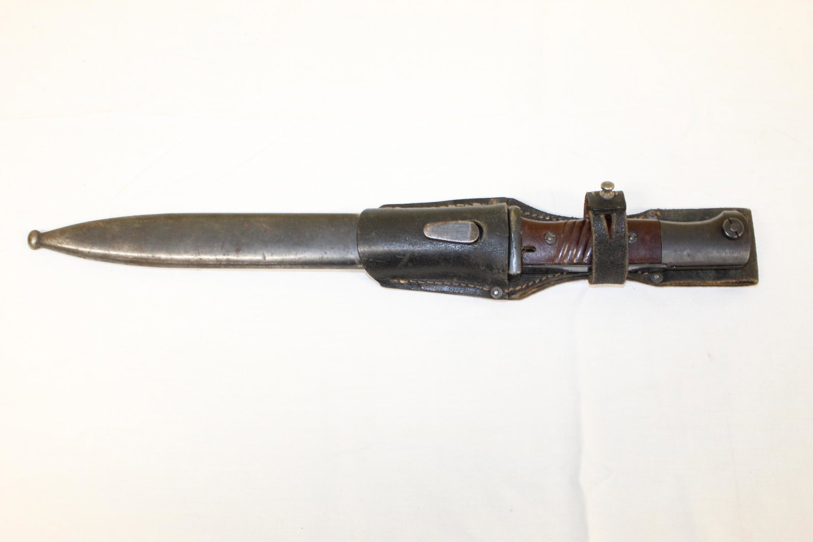Early bayonet in sheath and leather holder: This measures 16in L overall. The blade is embossed W. K. C. and comes with metal sheath. Leather holder is embossed on back KVZ 1943. This is in great overall condition with no damage or repairs seen