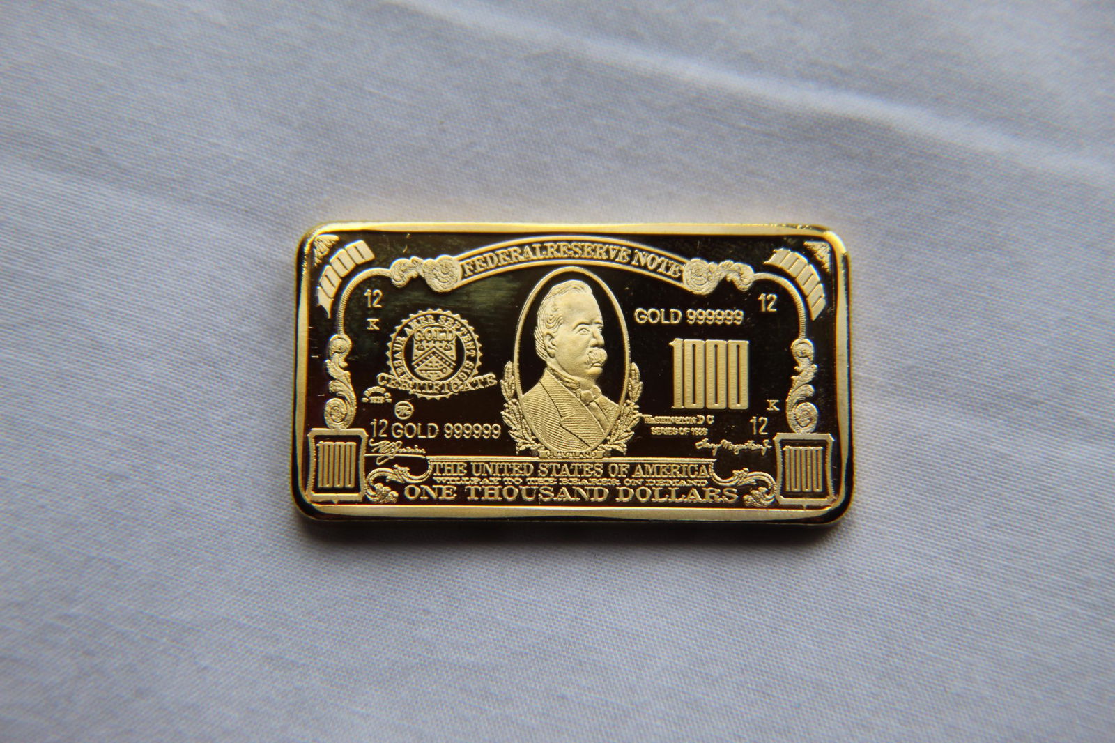 $1000 24K Gold Clad Bullion Bar: This 1000 24k Gold Clad Bullion Bar is laid out much like a paper dollar bill with the obverse side featuring a right facing profile of Cleveland in the center with the words Federal Reserve Note just
