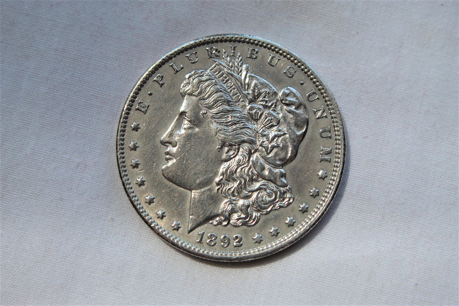 1892-CC Morgan Dollar: This 1892 Carson City $1 Morgan coin was designed by George T Morgan and is composed of silver 0.9000 measuring 38.1mm in diameter and weighing 26.7300g. Carson City Morgan Dollars make great addition