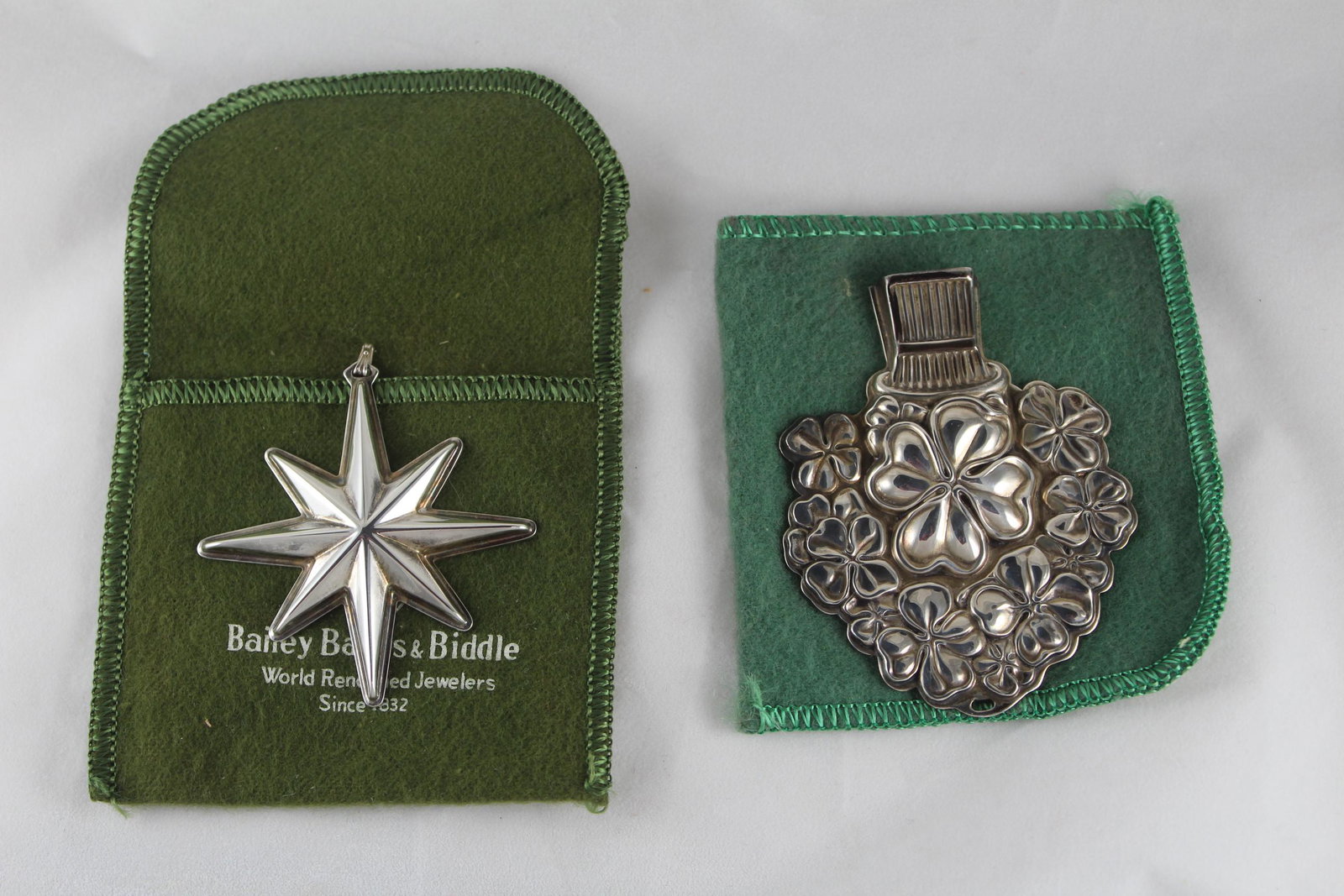 Two Sterling Silver Pieces: This lot includes two sterling silver pieces, including: a Good Luck Whistle by Reed and Barton, and a 1976 Christmas Star charm by Bailey Banks and Briddle. Both have small holding cases to keep them