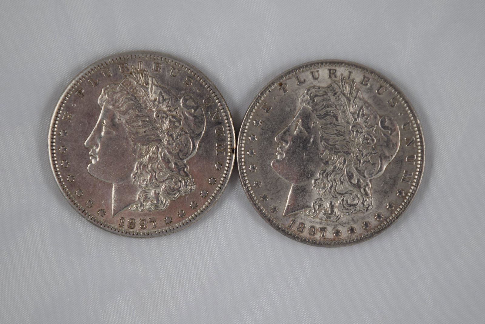 Lot of Two Morgan Dollars: This lot includes two Morgan Dollars: a 1897 Morgan Dollar and a 1897-S Morgan Dollar. These 1897 Morgan Dollars were designed by George T Morgan, are both composed of 0.900 silver, weigh approximatel