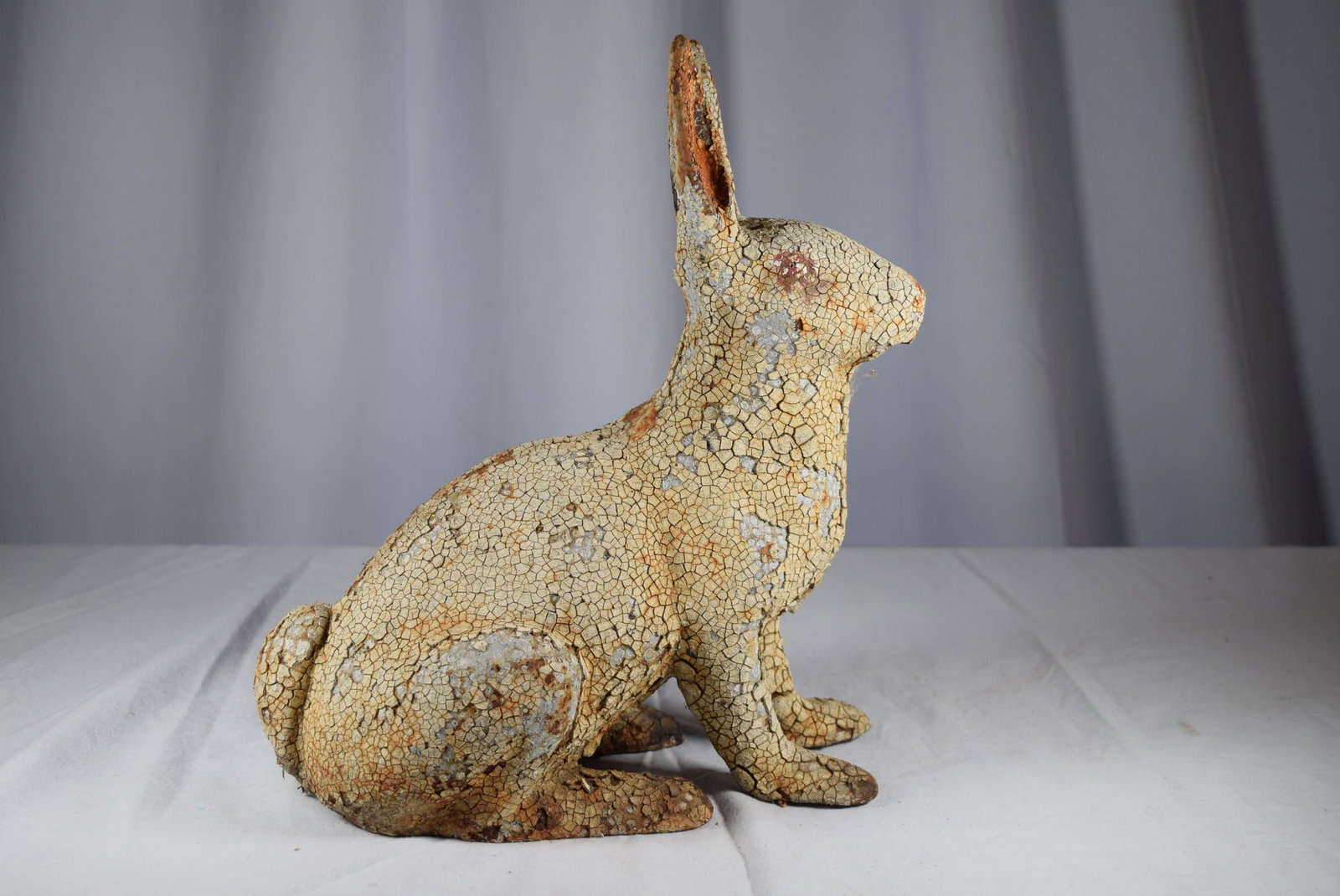 Early Cast Iron Rabbit Door Stop: Early cast iron rabbit door stop, has alligatoring white paint all over, as shown. Measures 12 inches tall from foot to tip of the ear as well as 12 inches long from tail to tip of the nose. As always