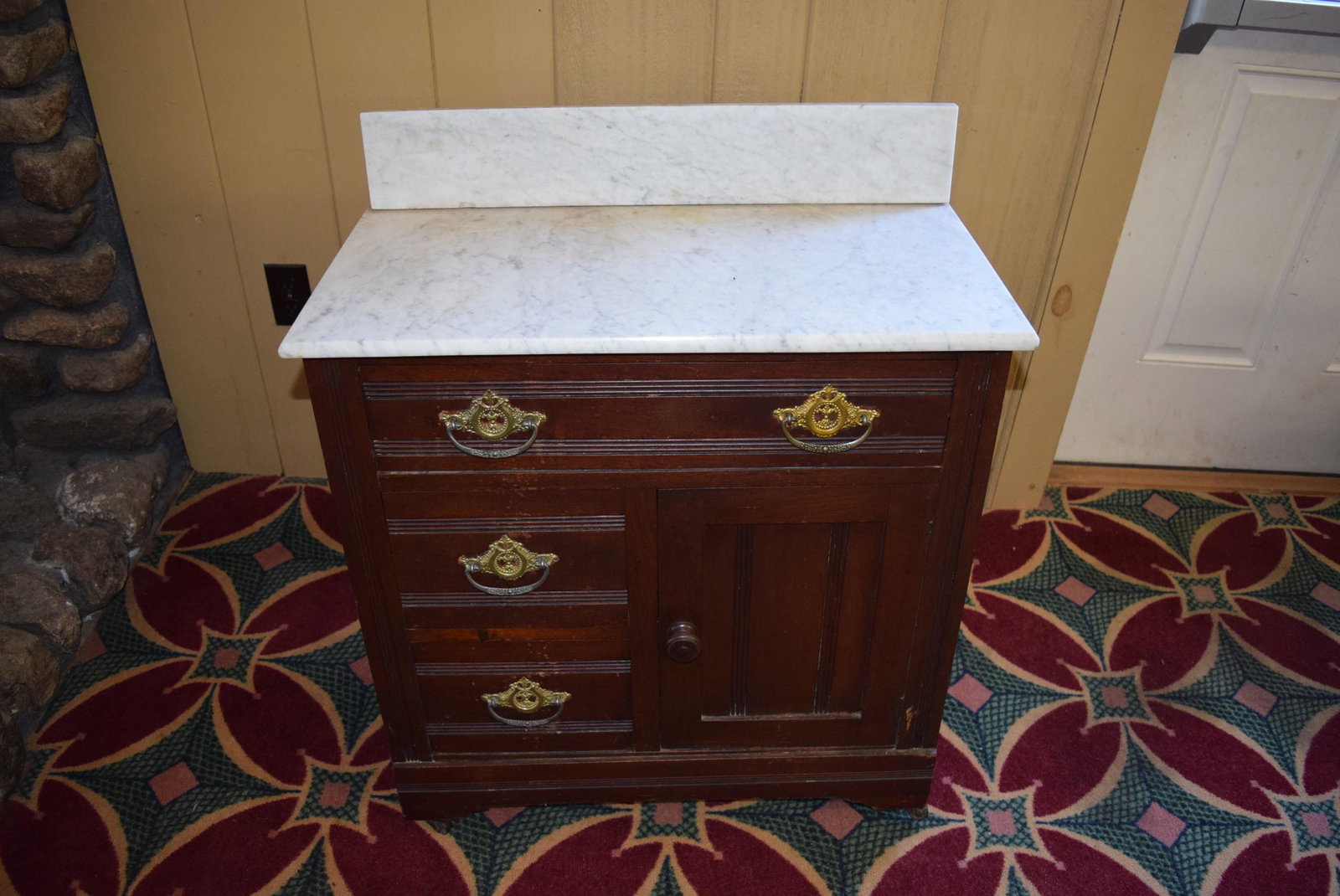 Victorian Marble Top Commode: Victorian Marble Top Commode; has three drawers and one cabinet; measures 28 inches wide X 14.5 inches deep X 33.25 inches tall along the back including the marble back. There is one caster missing on